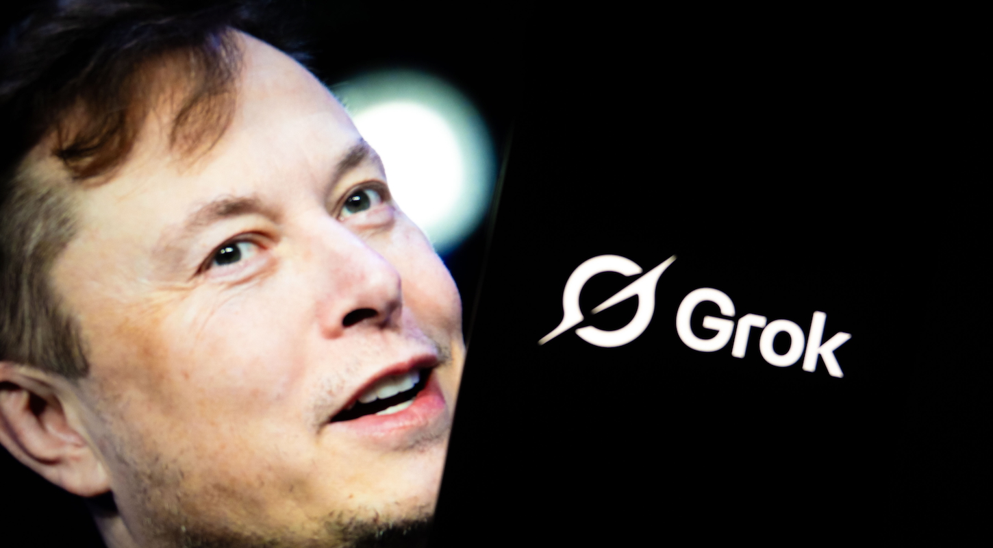 'Grok' logo is seen displayed on a mobile phone screen in front of a picture of Elon Musk in Ankara, Turkiye on July 17, 2025.