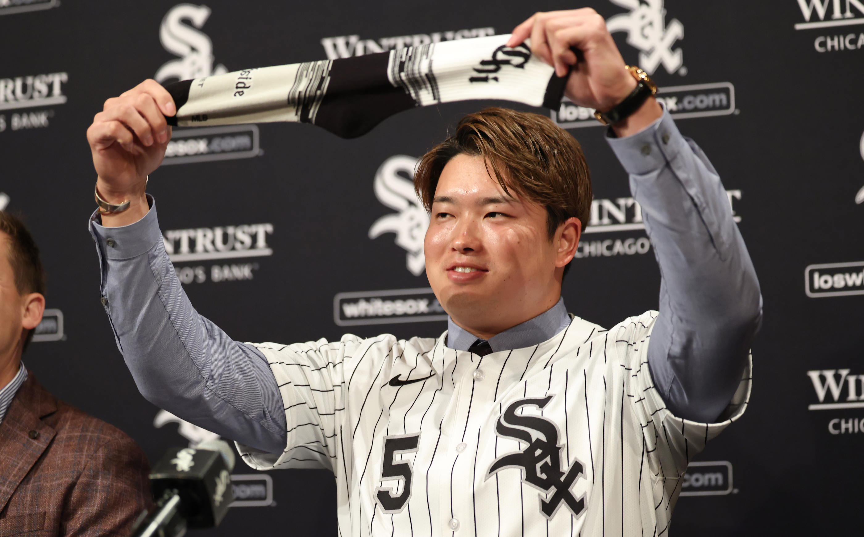 Munetaka Murakami #5 of the Chicago White Sox celebrates signing his first Major League Baseball contract by holding up a sock.