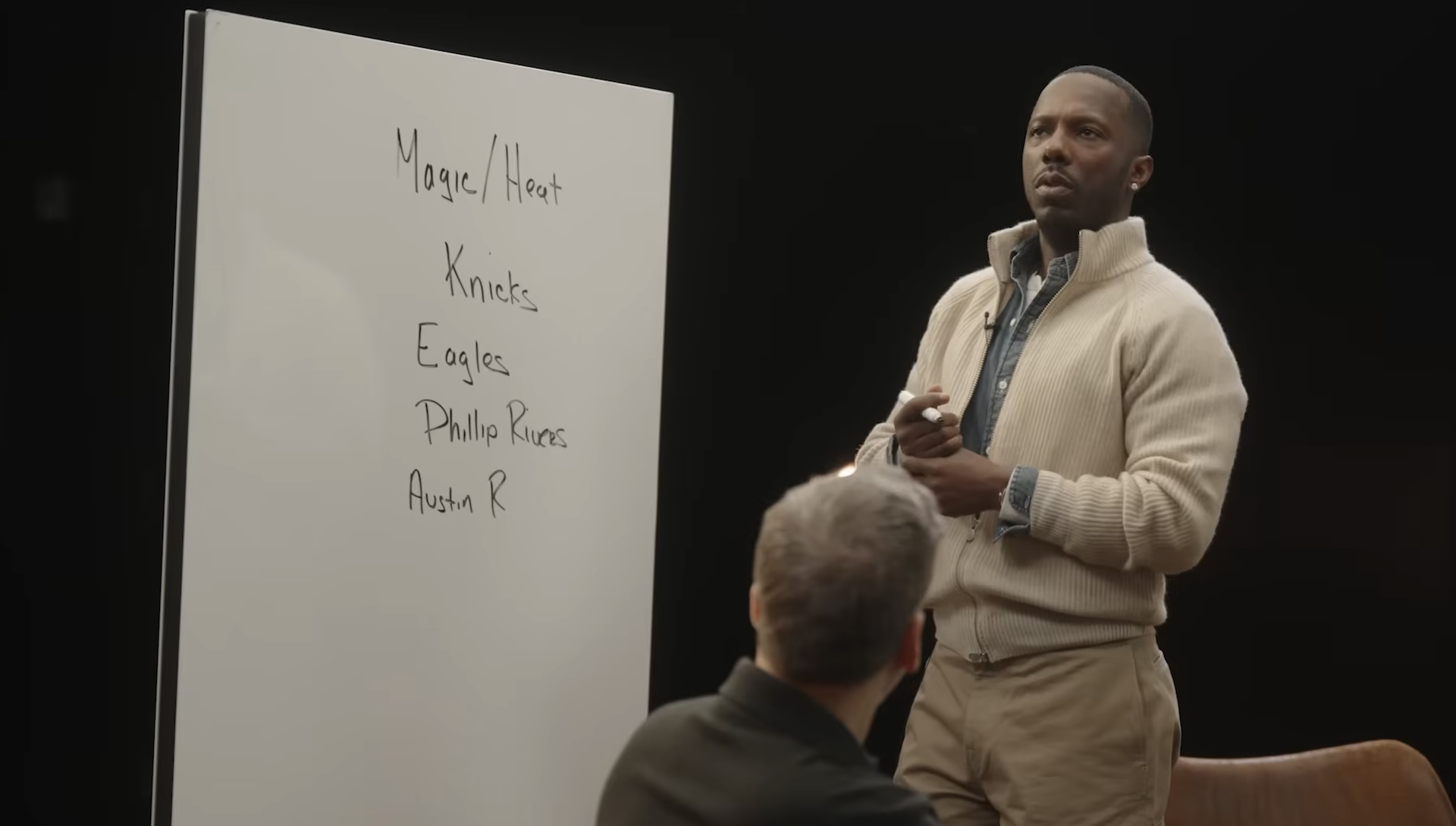 Rich Paul stands in front of a white board