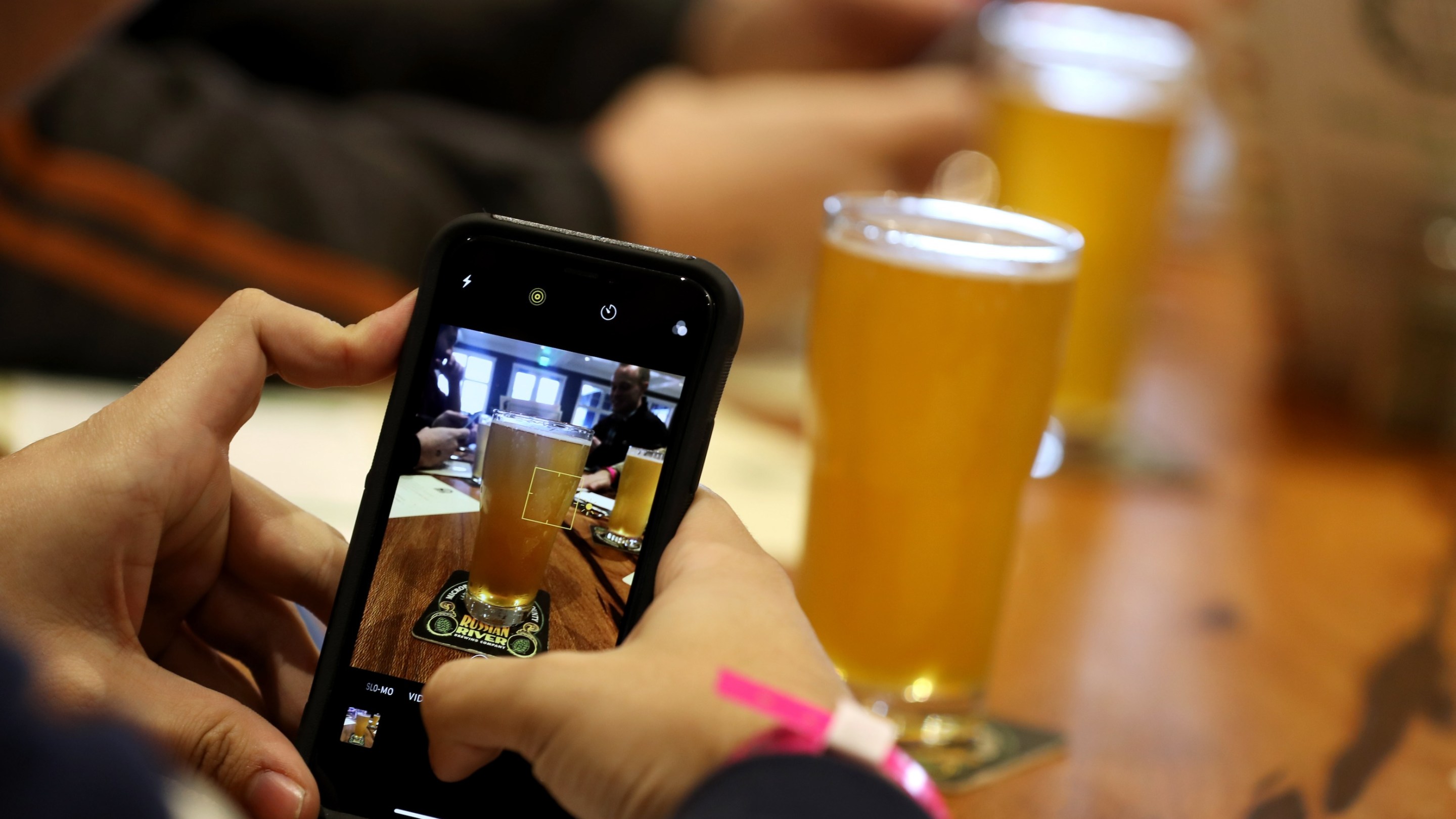 A customer takes a photograph of a glass of Russian River Brewing's Pliny the Younger at the Russian River Brewing Company on February 1, 2019 in Windsor, California.