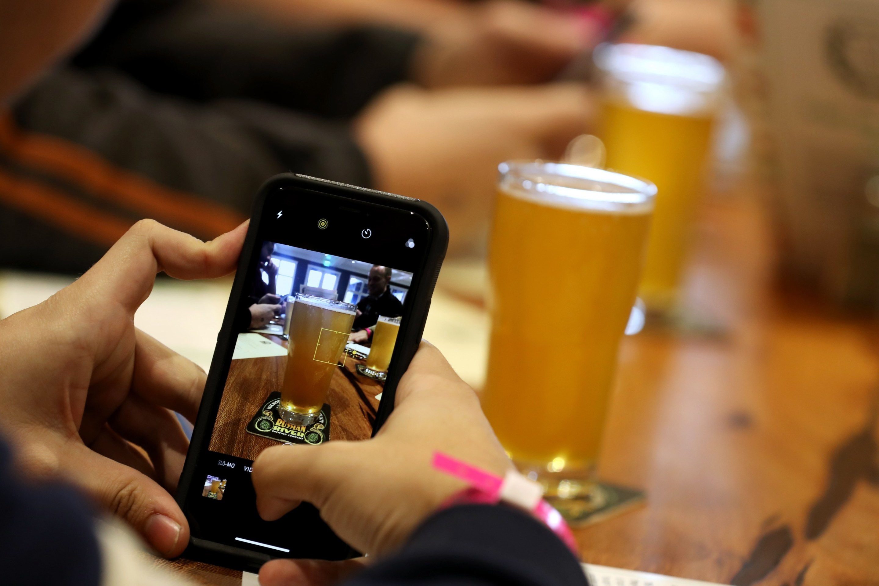 A customer takes a photograph of a glass of Russian River Brewing's Pliny the Younger at the Russian River Brewing Company on February 1, 2019 in Windsor, California.