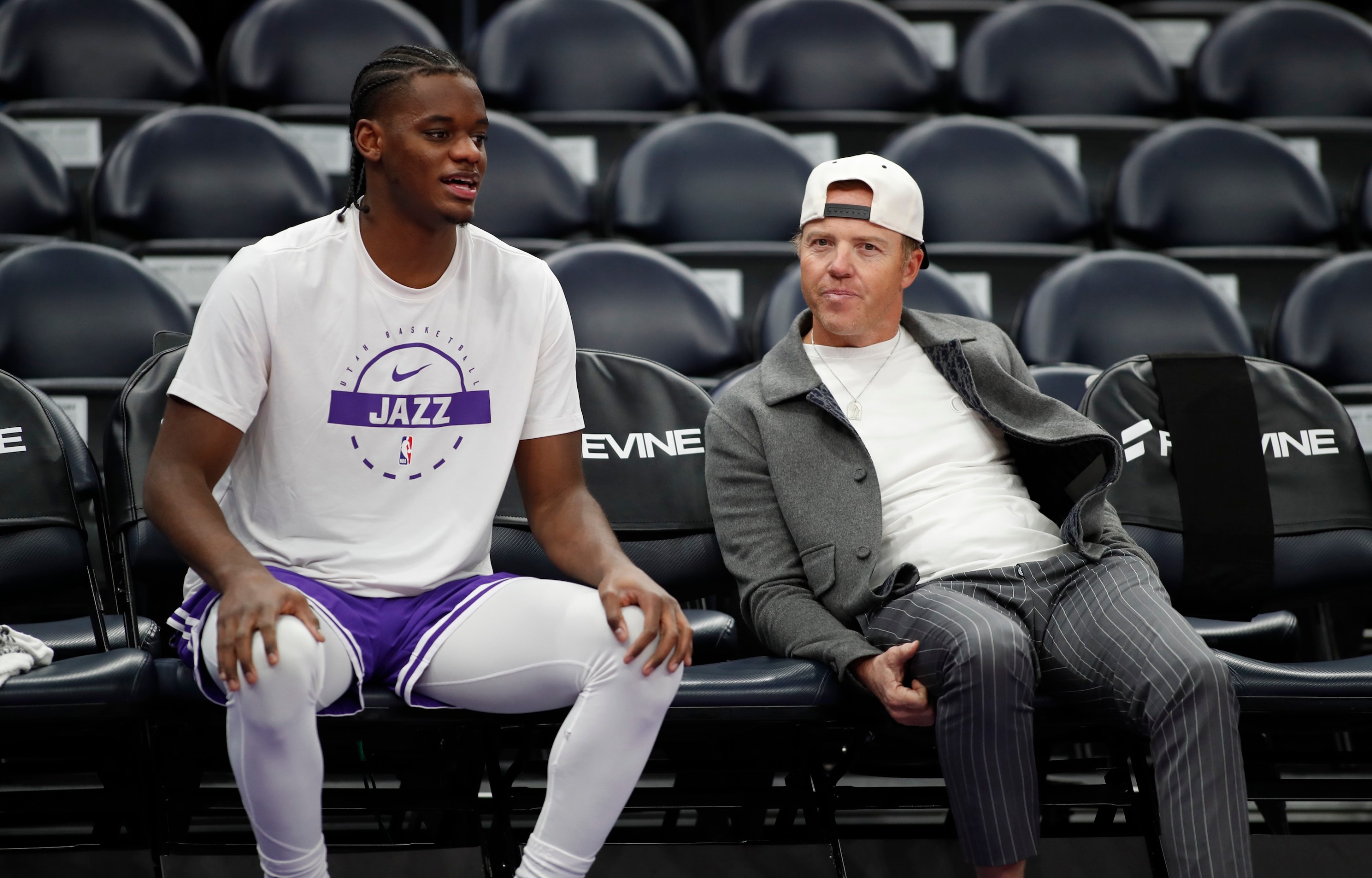 Taylor Hendricks of the Utah Jazz talks with team owner Ryan Smith during warmups before their game against the Dallas Mavericks at the Delta Center on January 8, 2026. Smith has a backwards baseball cap on, as always.