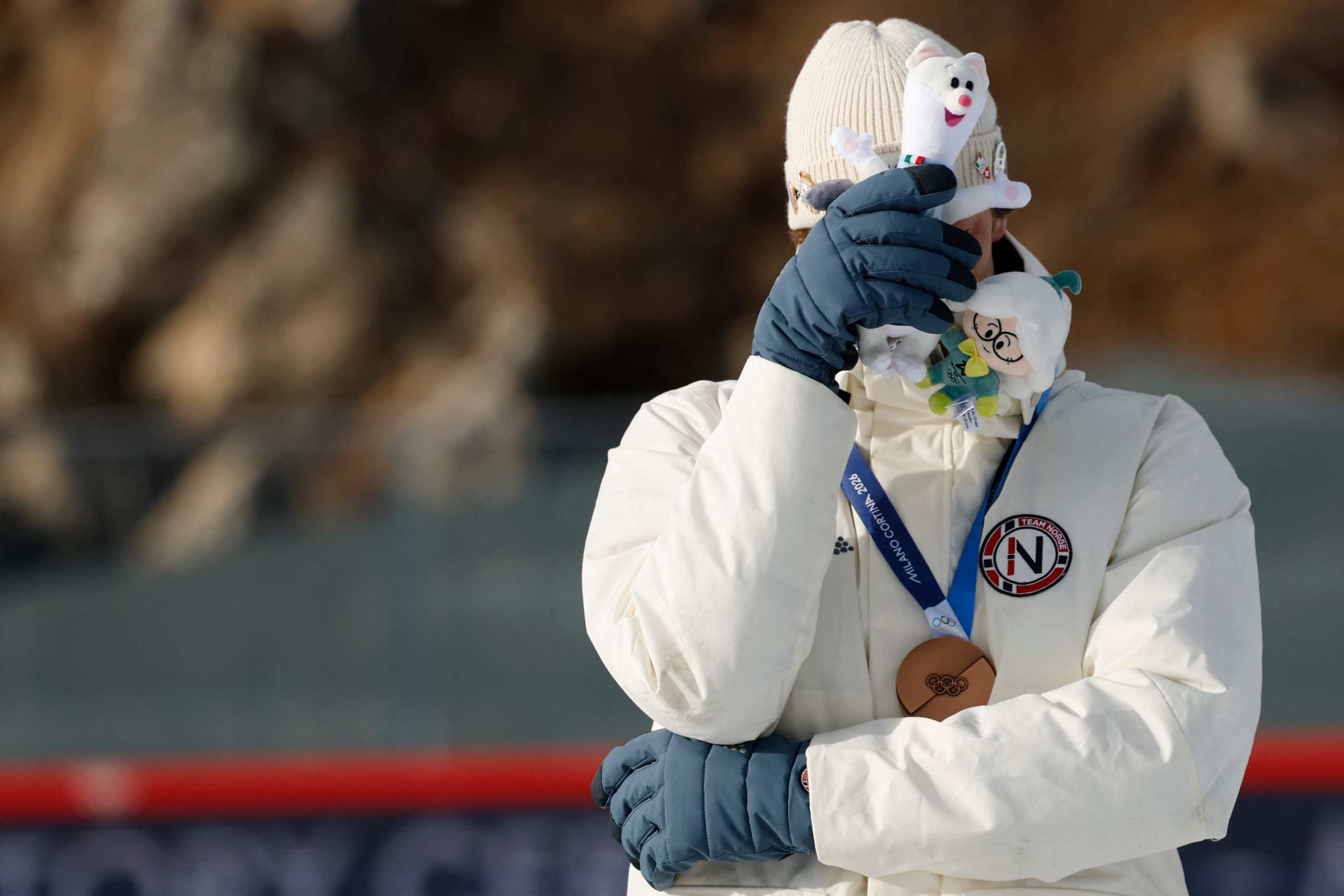 Bronze medallist Norway's Sturla Holm Laegreid covers his face on the podium