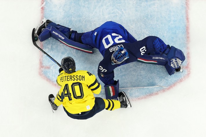 MILAN, ITALY - FEBRUARY 11: (EDITOR'S NOTE: Image was captured using a remote camera positioned above the field of play.) Damian Clara #20 of Team Italy saves a shot by Elias Pettersson #40 of Team Sweden in the third period during the Men's Preliminary Group B match between Sweden and Italy on day five of the Milano Cortina 2026 Winter Olympic games at Milano Santagiulia Ice Hockey Arena on February 11, 2026 in Milan, Italy. (Photo by Bruce Bennett/Getty Images)
