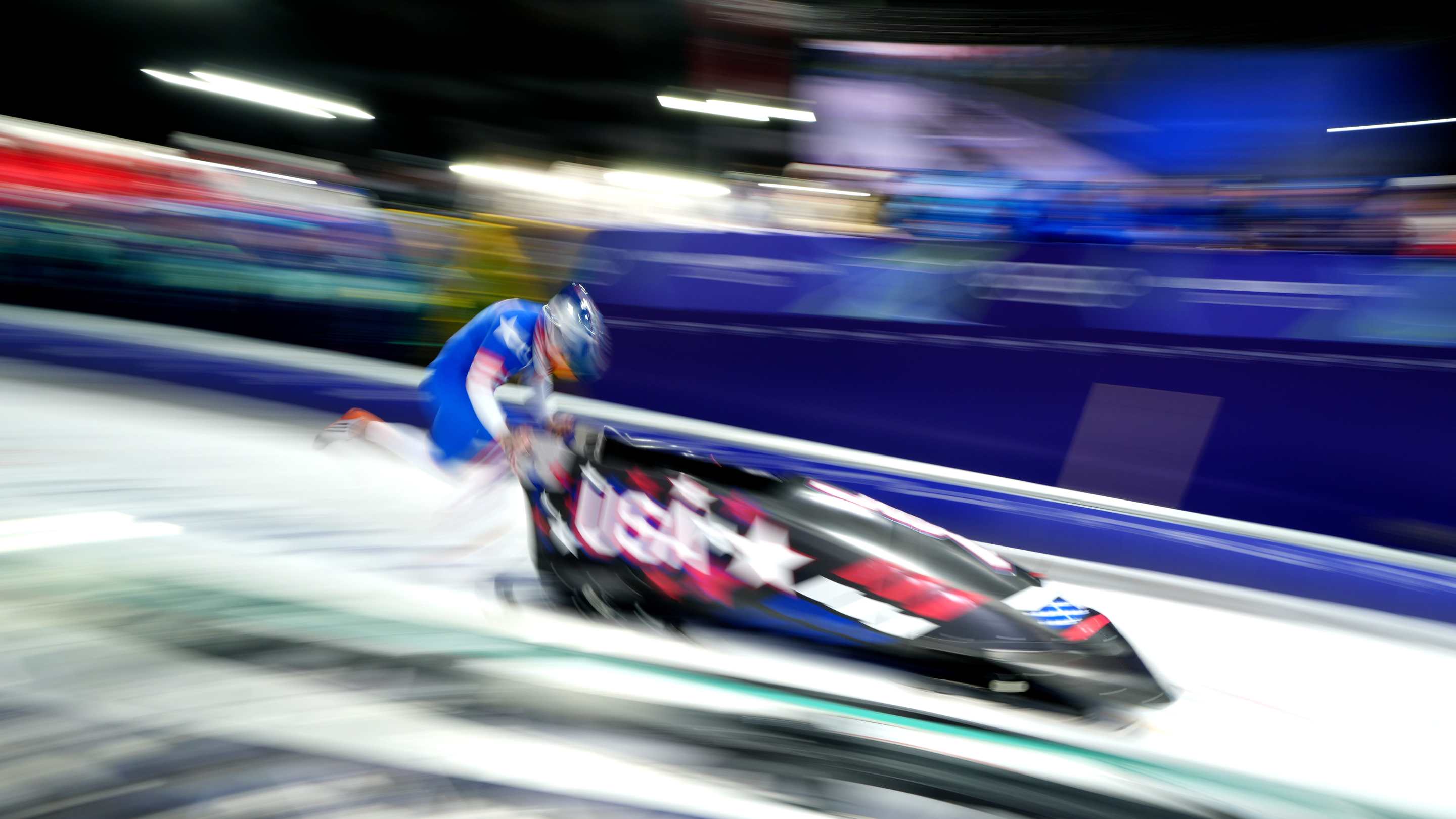 a USA bobsledder pushes a sled (with a long exposure so it looks artsy)