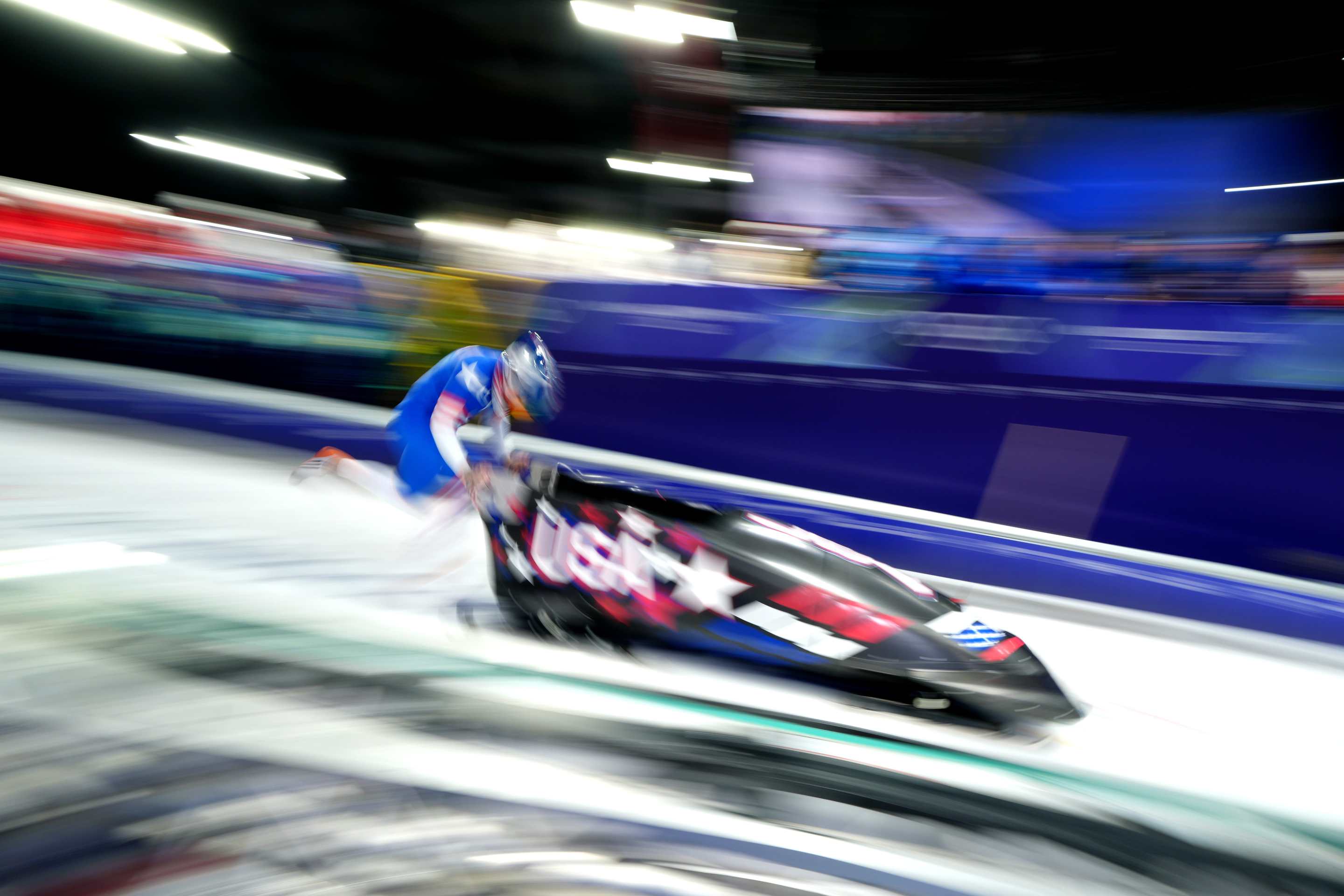 a USA bobsledder pushes a sled (with a long exposure so it looks artsy)