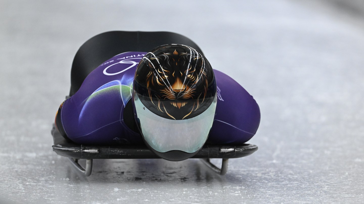 Lin Qinwei wears a gold-on-black lion design with a frosted visor.