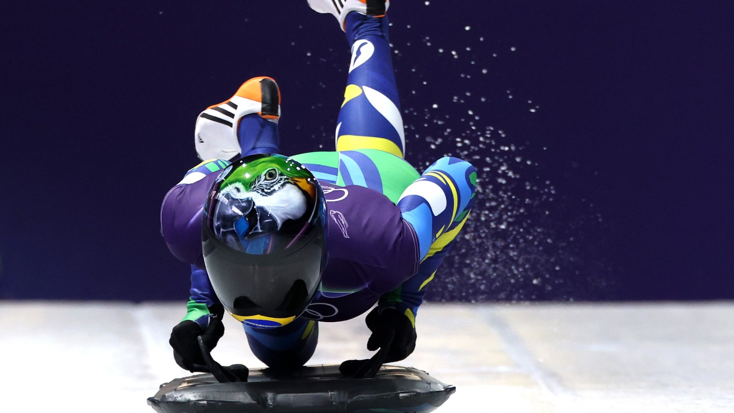 Nicole Rocha Silveira of Team Brazil wears a parrot helmet and a colorful skinsuit.