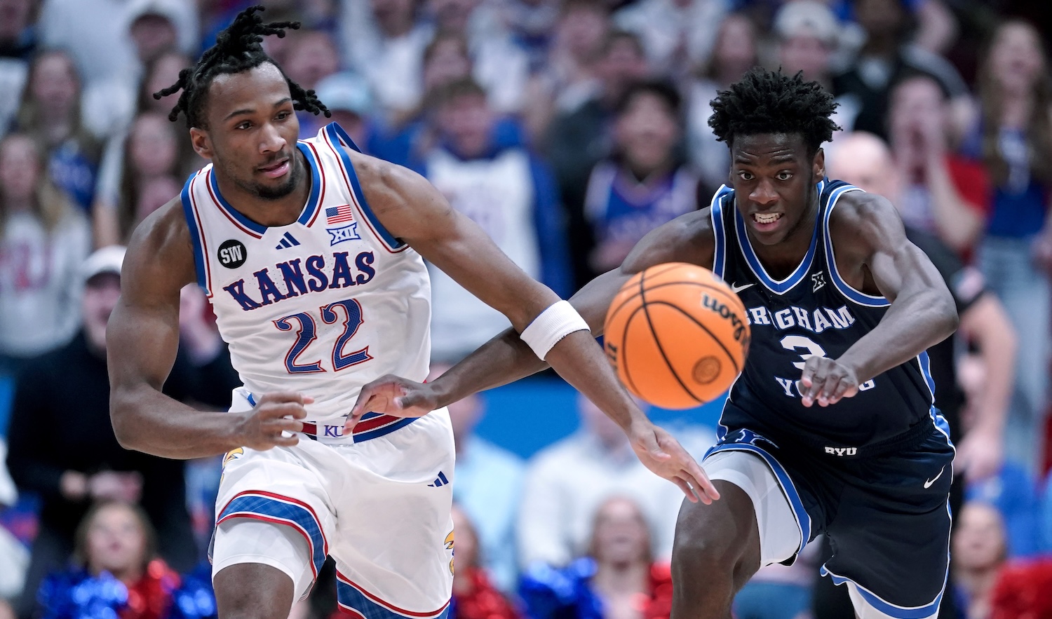 LAWRENCE, KANSAS - JANUARY 31: Darryn Peterson #22 of the Kansas Jayhawks and forward AJ Dybantsa #3 of the BYU Cougars chase down a loose ball in the first half at Allen Fieldhouse on January 31, 2026 in Lawrence, Kansas. (Photo by Ed Zurga/Getty Images)
