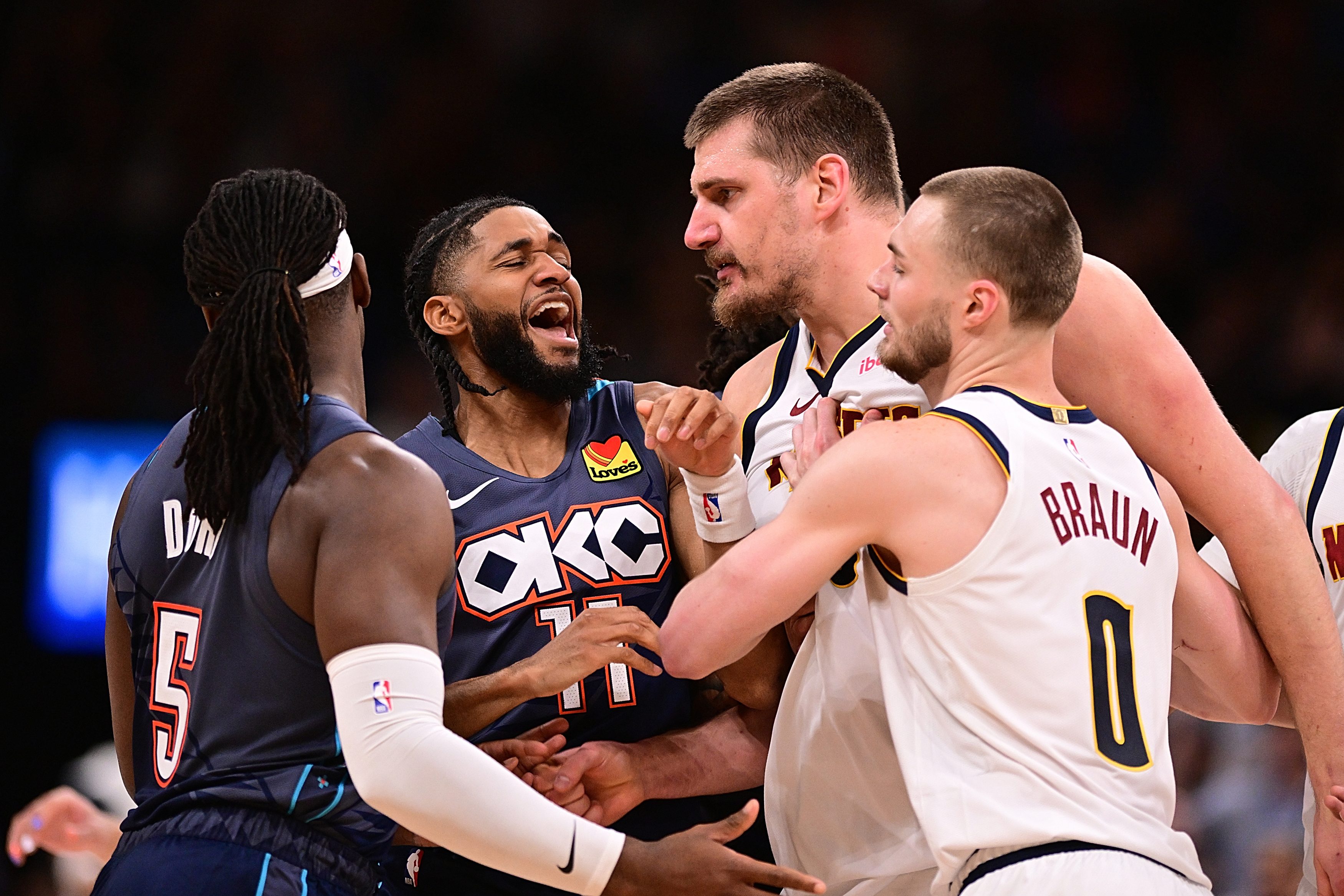 Isaiah Joe #11 of the Oklahoma City Thunder gets in between Luguentz Dort #5 of the Oklahoma City Thunder and Nikola Jokic #15 of the Denver Nuggets