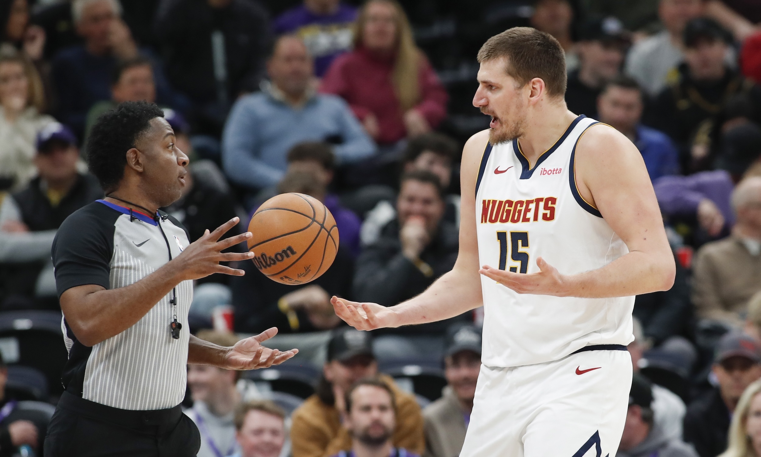 Nikola Jokic complains to a ref.