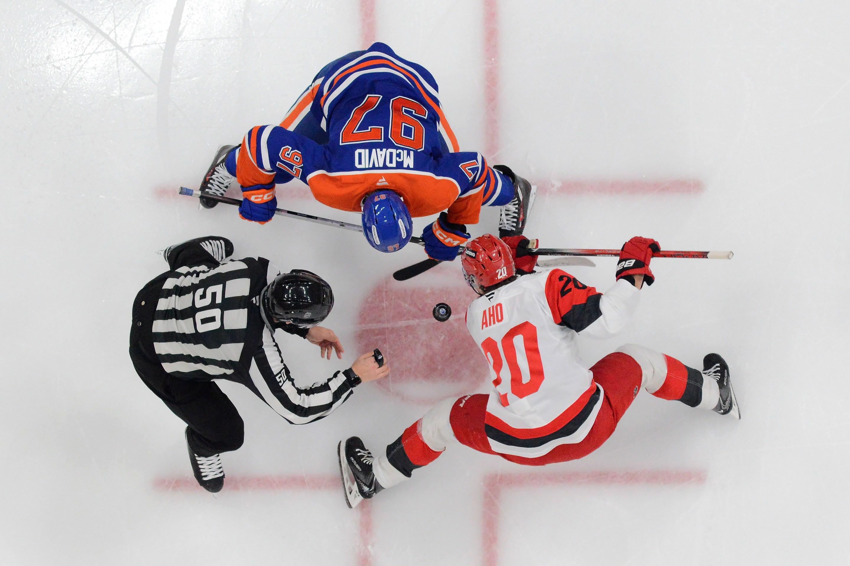 Connor McDavid #97 of the Edmonton Oilers faces off against Sebastian Aho