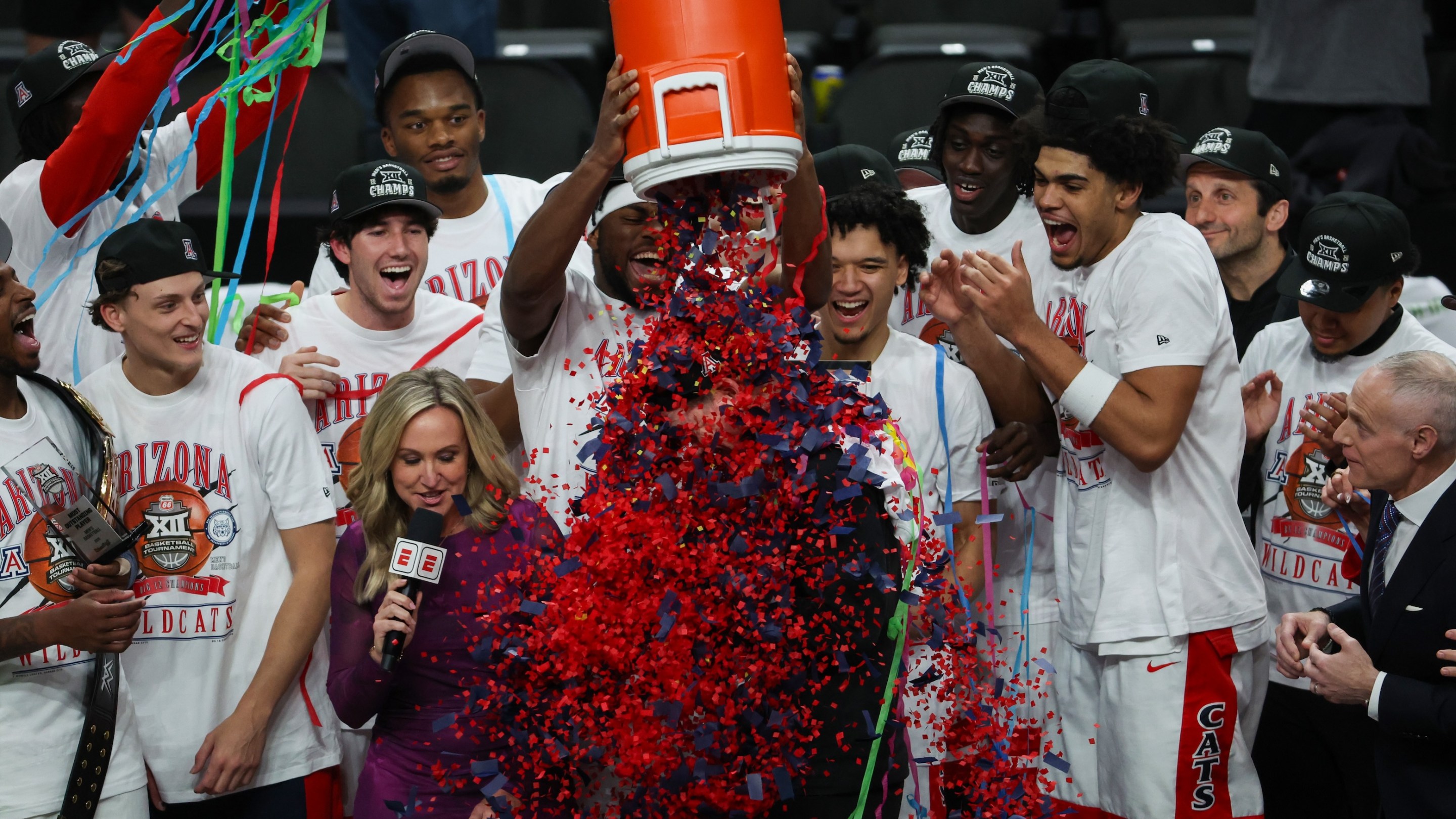 Arizona Wildcats players pour confetti on the head coach Tommy Lloyd after winning the Big 12 Tournament championship game between the Houston Cougars and the Arizona Wildcats on March 14, 2026.