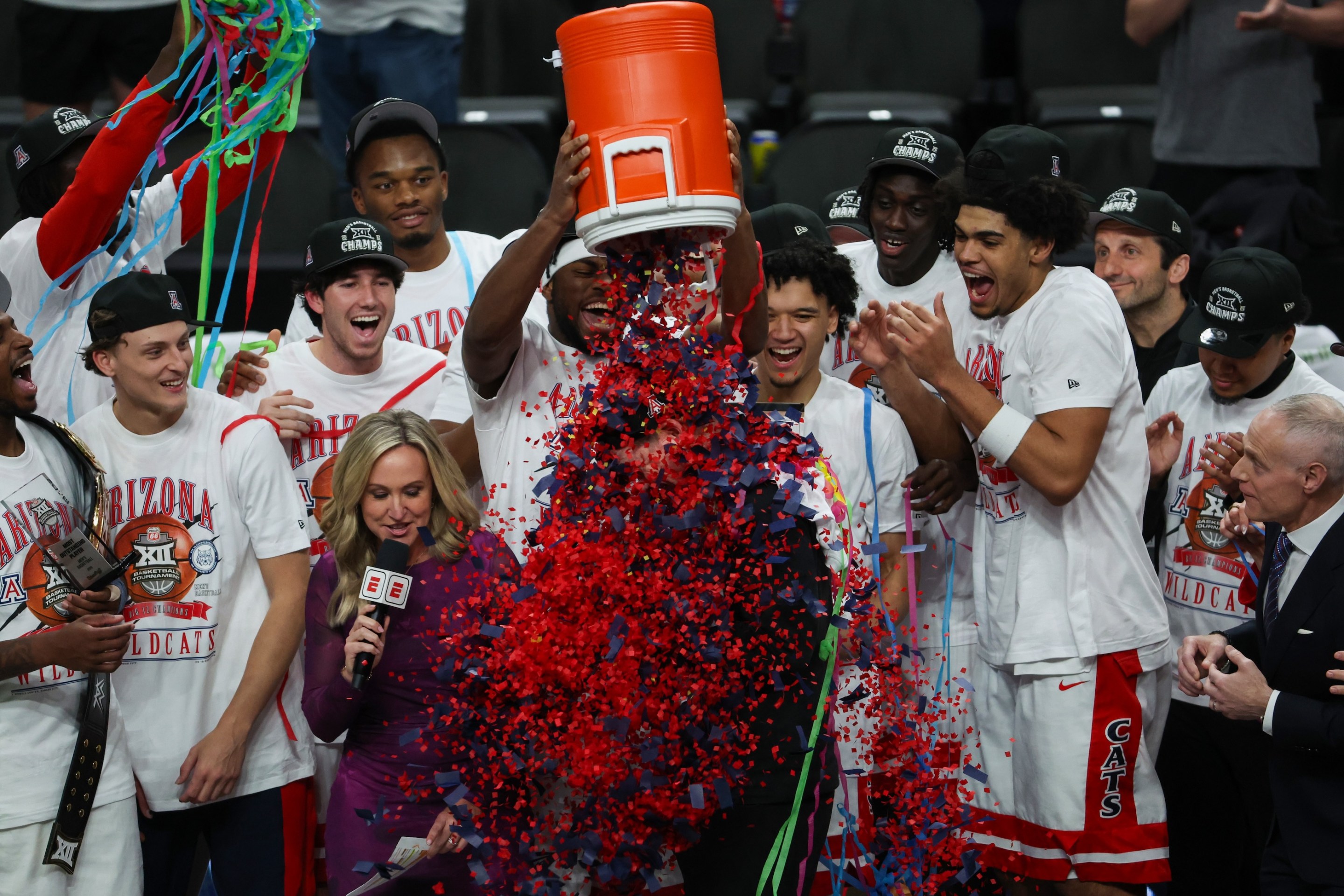 Arizona Wildcats players pour confetti on the head coach Tommy Lloyd after winning the Big 12 Tournament championship game between the Houston Cougars and the Arizona Wildcats on March 14, 2026.