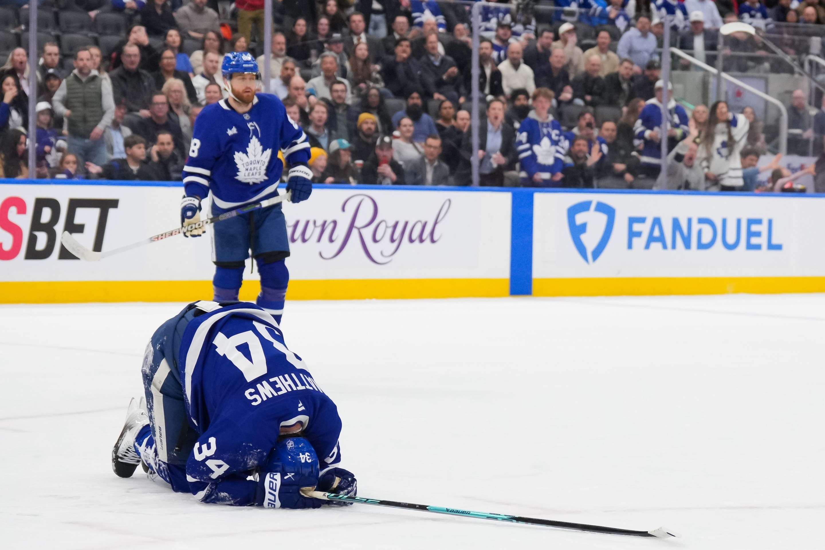 Auston Matthews of the Toronto Maple Leafs kneels on the ice after being kneed by Radko Gudas of the Anaheim Mighty Ducks on March 12, 2026 in Toronto.