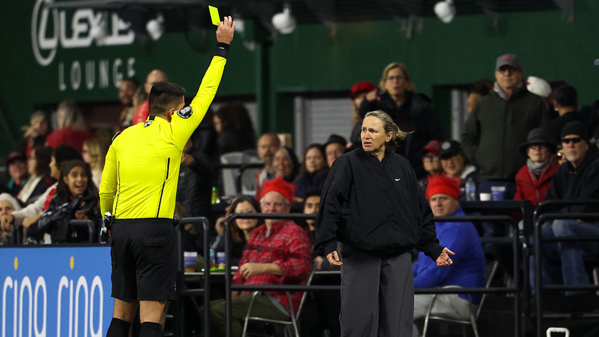 Laura Harvey looks perplexed while receiving a yellow card