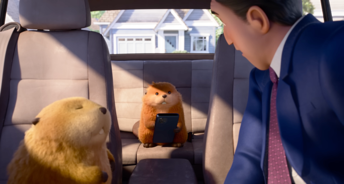 a still from the trailer for hoppers that shows two beavers with beady eyes in a car with a white guy mayor