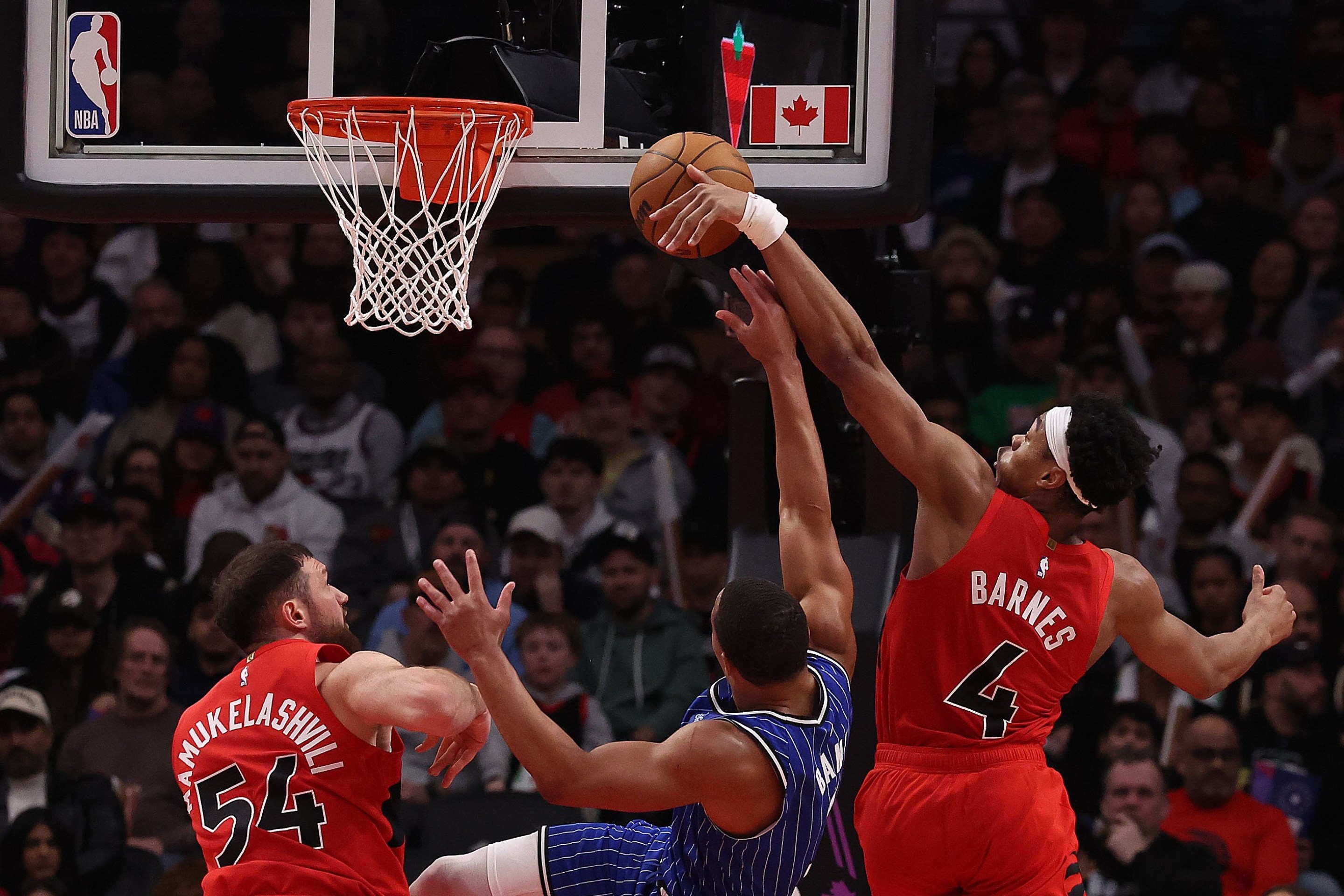 Forward Scottie Barnes #4 of the Toronto Raptors blocks guard Desmond Bane #3 of the Orlando Magic and forward Sandro Mamukelashvili #54 of the Toronto Raptors as the Toronto Raptors beat the Orlando Magic 139-87 in a game that included a 31-0 run by the Toronto Raptors at Scotiabank Arena in Toronto. March 29, 2026.