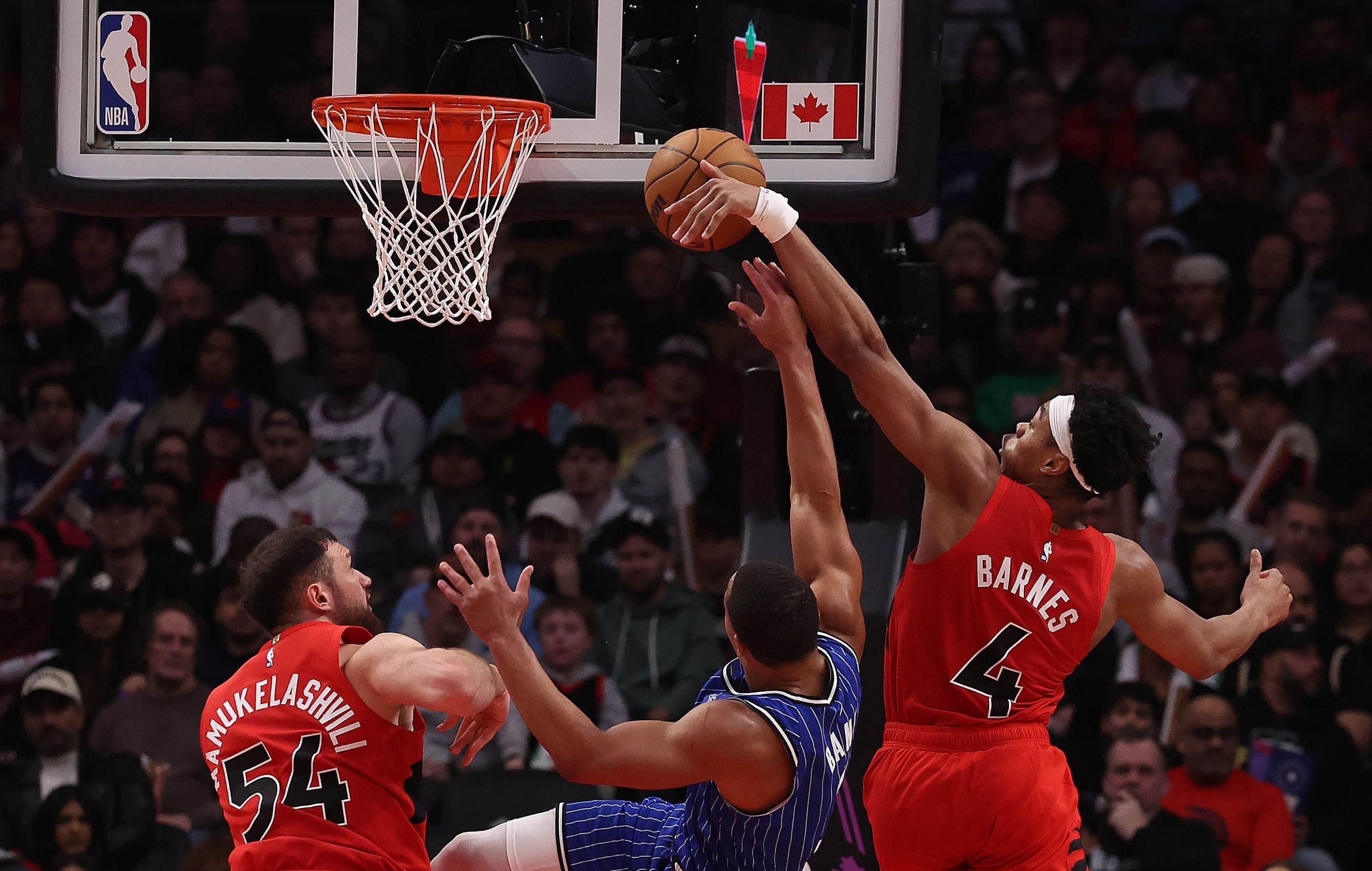 Forward Scottie Barnes #4 of the Toronto Raptors blocks guard Desmond Bane #3 of the Orlando Magic and forward Sandro Mamukelashvili #54 of the Toronto Raptors as the Toronto Raptors beat the Orlando Magic 139-87 in a game that included a 31-0 run by the Toronto Raptors at Scotiabank Arena in Toronto. March 29, 2026.