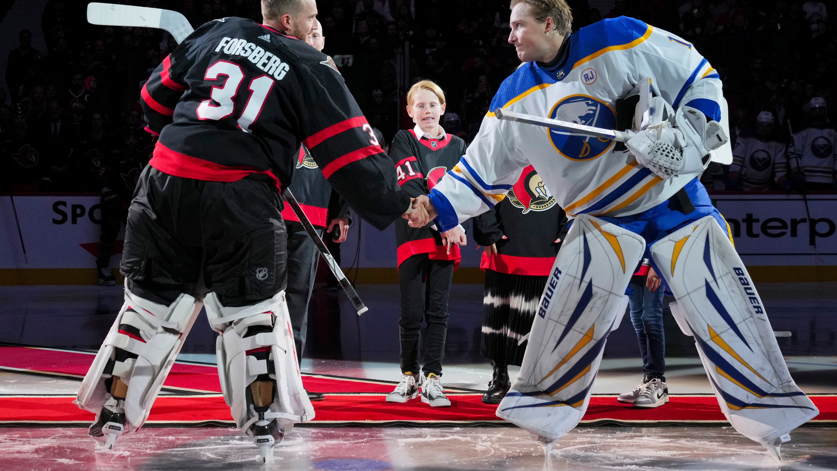 OTTAWA, CANADA - OCTOBER 24: Anton Forsberg #31 of the Ottawa Senators and Ukko-Pekka Luukkonen #1 of the Buffalo Sabres shake hands after a ceremonial face-off recognizing Craig Anderson after he signed a one-day contract to retire as a member of the Ottawa Senators at Canadian Tire Centre on October 24, 2023 in Ottawa, Ontario, Canada. (Photo by André Ringuette/NHLI via Getty Images)
