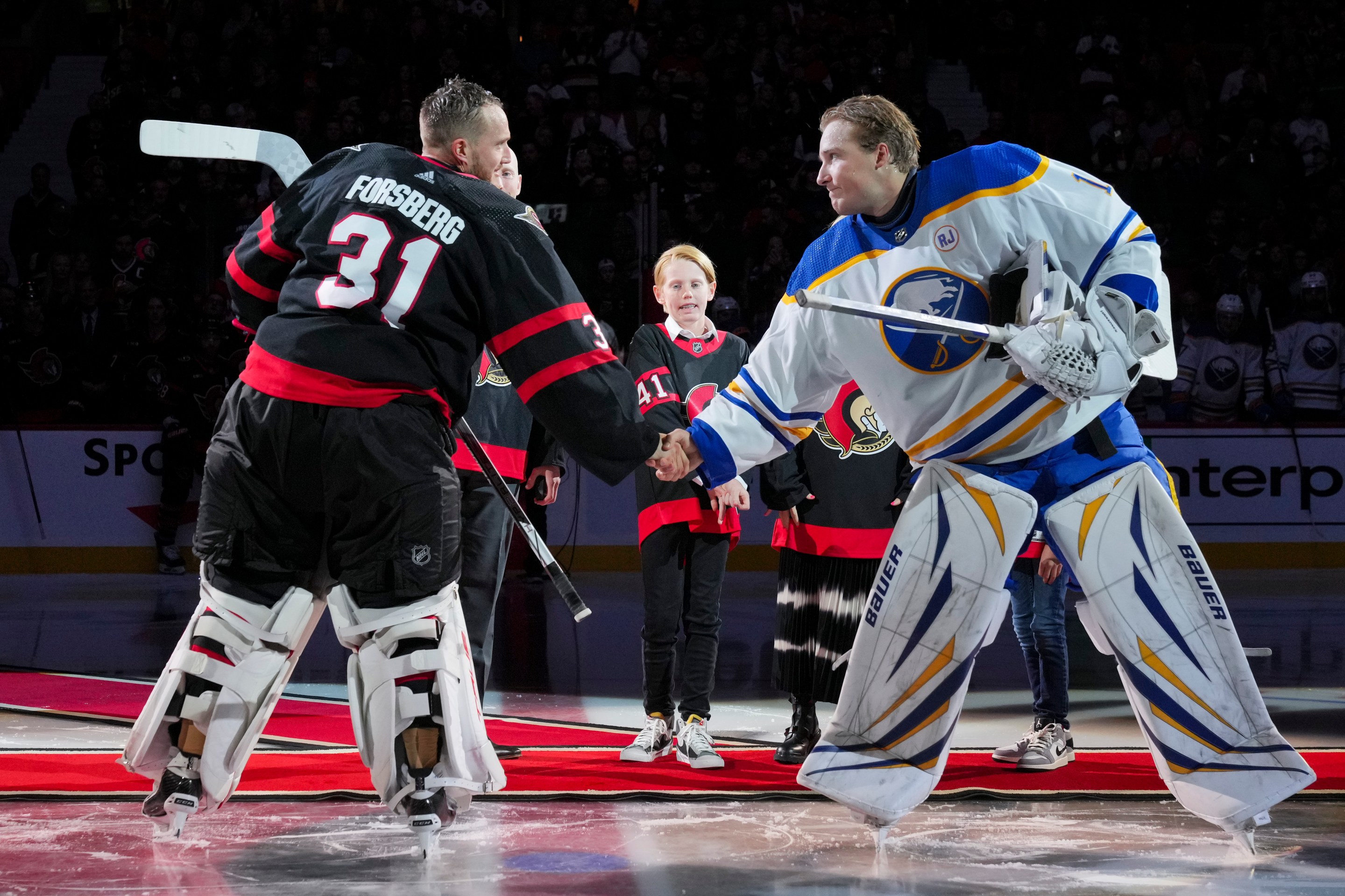 OTTAWA, CANADA - OCTOBER 24: Anton Forsberg #31 of the Ottawa Senators and Ukko-Pekka Luukkonen #1 of the Buffalo Sabres shake hands after a ceremonial face-off recognizing Craig Anderson after he signed a one-day contract to retire as a member of the Ottawa Senators at Canadian Tire Centre on October 24, 2023 in Ottawa, Ontario, Canada. (Photo by André Ringuette/NHLI via Getty Images)