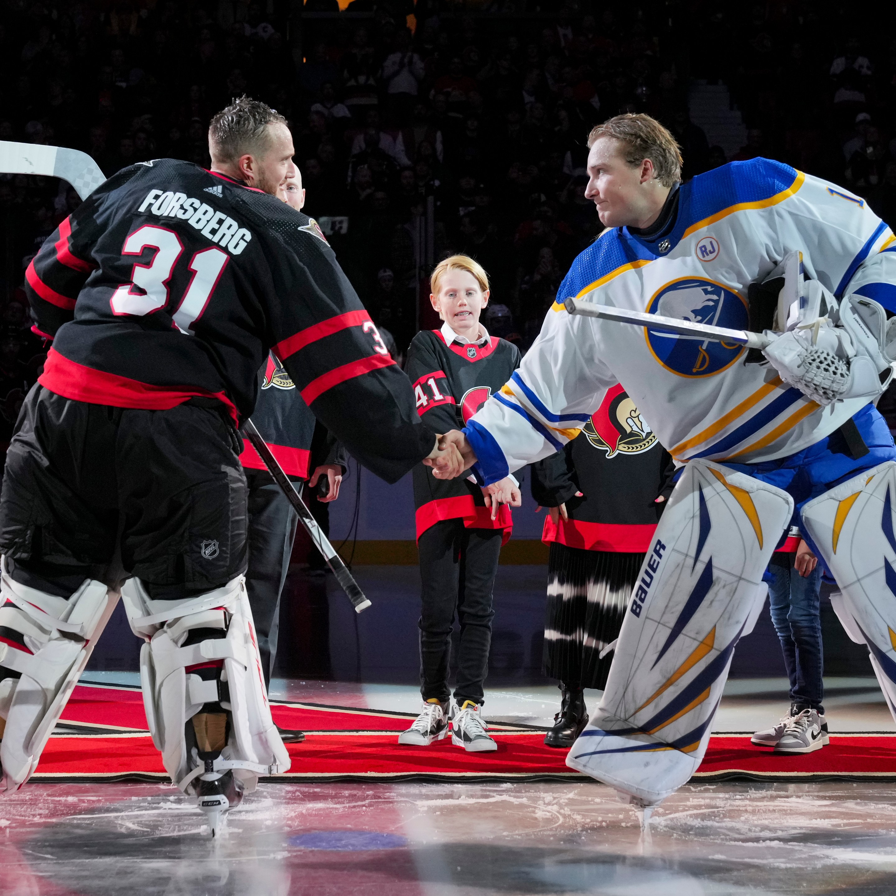 OTTAWA, CANADA - OCTOBER 24: Anton Forsberg #31 of the Ottawa Senators and Ukko-Pekka Luukkonen #1 of the Buffalo Sabres shake hands after a ceremonial face-off recognizing Craig Anderson after he signed a one-day contract to retire as a member of the Ottawa Senators at Canadian Tire Centre on October 24, 2023 in Ottawa, Ontario, Canada. (Photo by André Ringuette/NHLI via Getty Images)