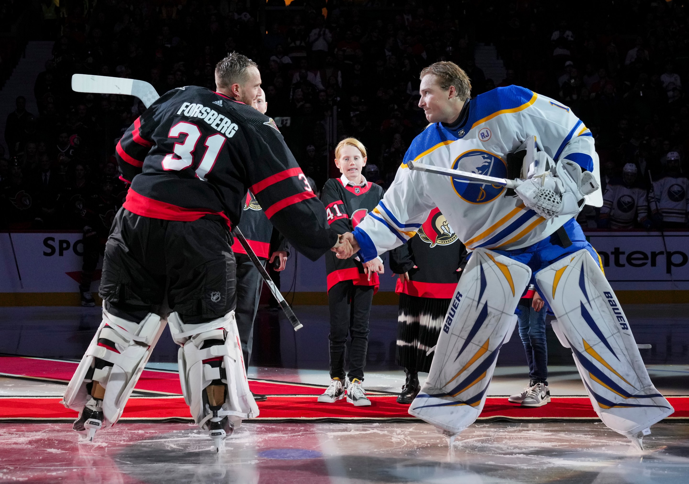 OTTAWA, CANADA - OCTOBER 24: Anton Forsberg #31 of the Ottawa Senators and Ukko-Pekka Luukkonen #1 of the Buffalo Sabres shake hands after a ceremonial face-off recognizing Craig Anderson after he signed a one-day contract to retire as a member of the Ottawa Senators at Canadian Tire Centre on October 24, 2023 in Ottawa, Ontario, Canada. (Photo by André Ringuette/NHLI via Getty Images)
