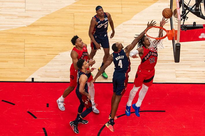 Collin Murray-Boyles #12 of the Toronto Raptors drives to the basket against Evan Mobley #4 of the Cleveland Cavaliers