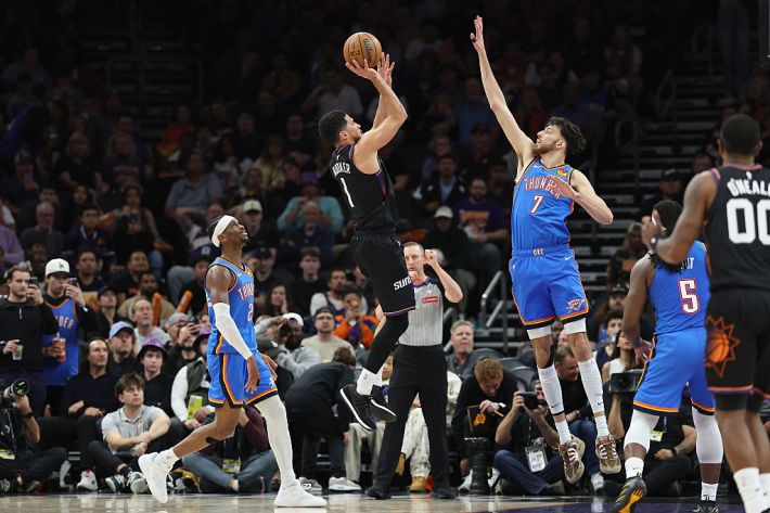 Devin Booker #1 of the Phoenix Suns attempts a shot over Chet Holmgren #7 of the Oklahoma City Thunder