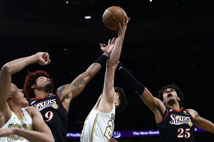 Hugo Gonzalez #28 of the Boston Celtics goes up for a rebound between Dominick Barlow #25 and Kelly Oubre Jr. #9 of the Philadelphia 76ers