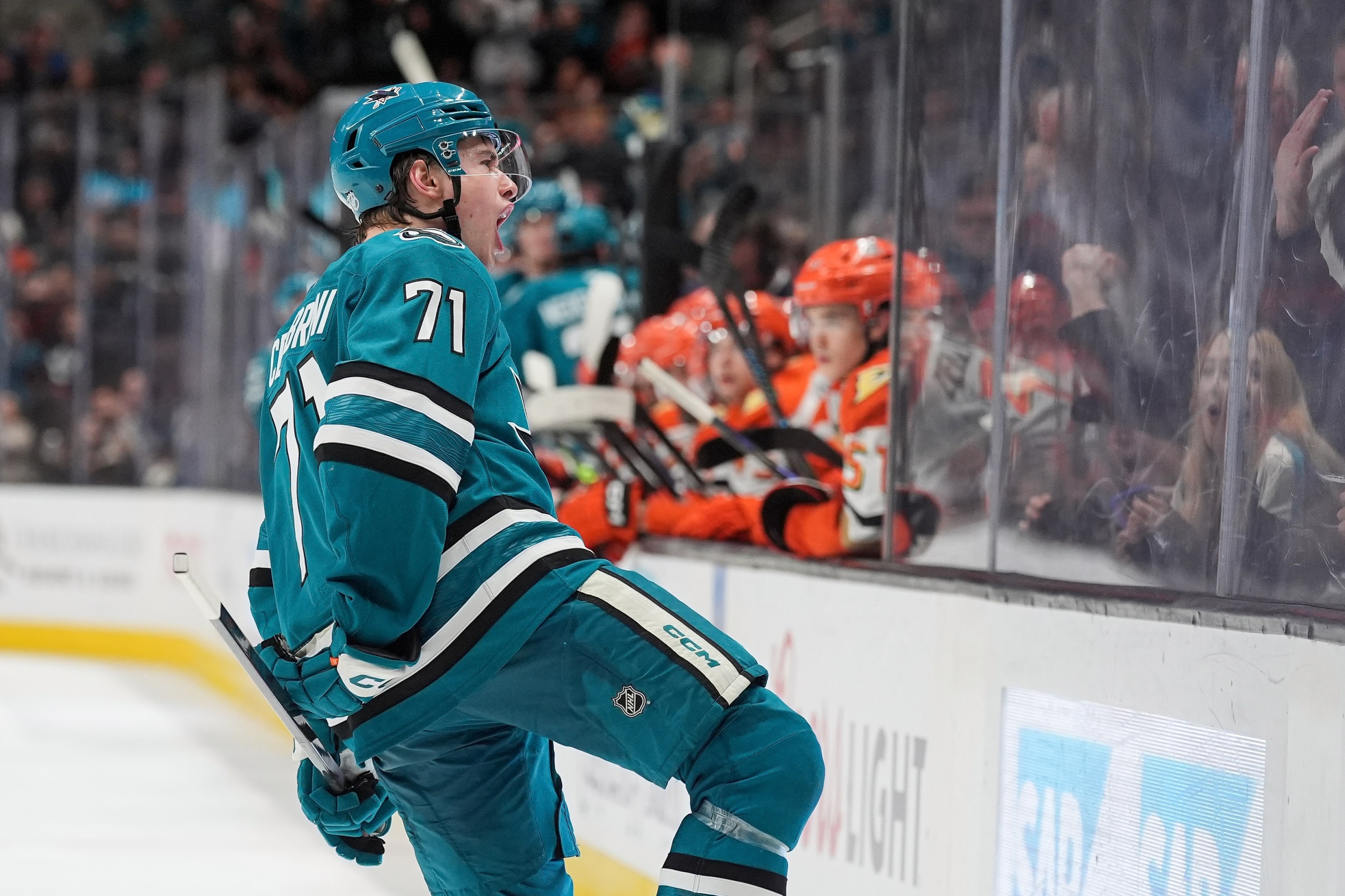 Macklin Celebrini of the San Jose Sharks celebrates scoring a goal in the third period against the Anaheim Ducks at SAP Center on April 1, 2026 in San Jose, California. You can see the Ducks guys looking upset in the background.