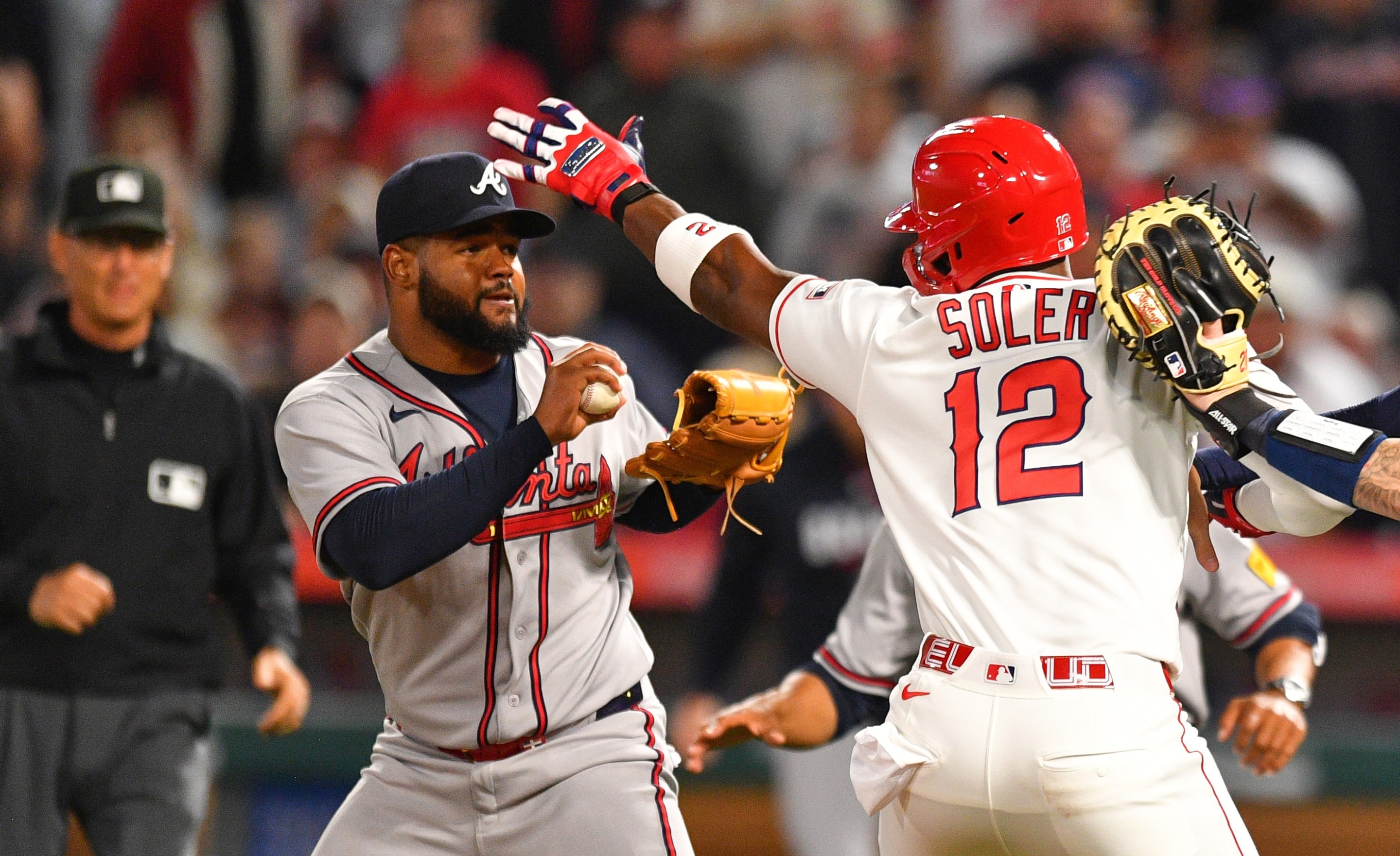 ANAHEIM, CA - APRIL 07: Atlanta Braves catcher Jonah Heim (20) tries to hold back Los Angeles Angels designated hitter Jorge Soler (12) as he swings a punch at Atlanta Braves pitcher Reynaldo Lopez (40) on the mound as home plate umpire Edwin Moscoso trails the play during the MLB game between the Atlanta Braves and the Los Angeles Angels on April 7, 2026 at Angel Stadium in Anaheim, CA. (Photo by Brian Rothmuller/Icon Sportswire)