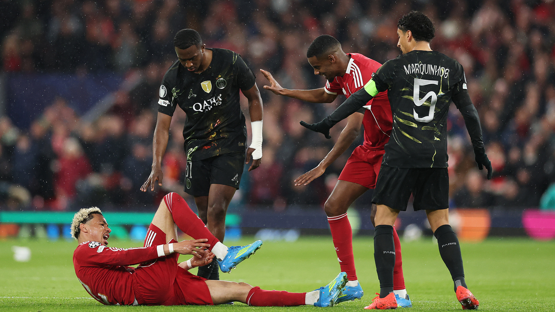 Hugo Ekitike of Liverpool is checked on by Alexander Isak of Liverpool and Marquinhos of Paris Saint-Germain as he holds his ankle as he appears to be injured during the UEFA Champions League 2025/26 Quarter-Final Second Leg match between Liverpool FC and Paris Saint-Germain FC at Anfield on April 14, 2026 in Liverpool, England.