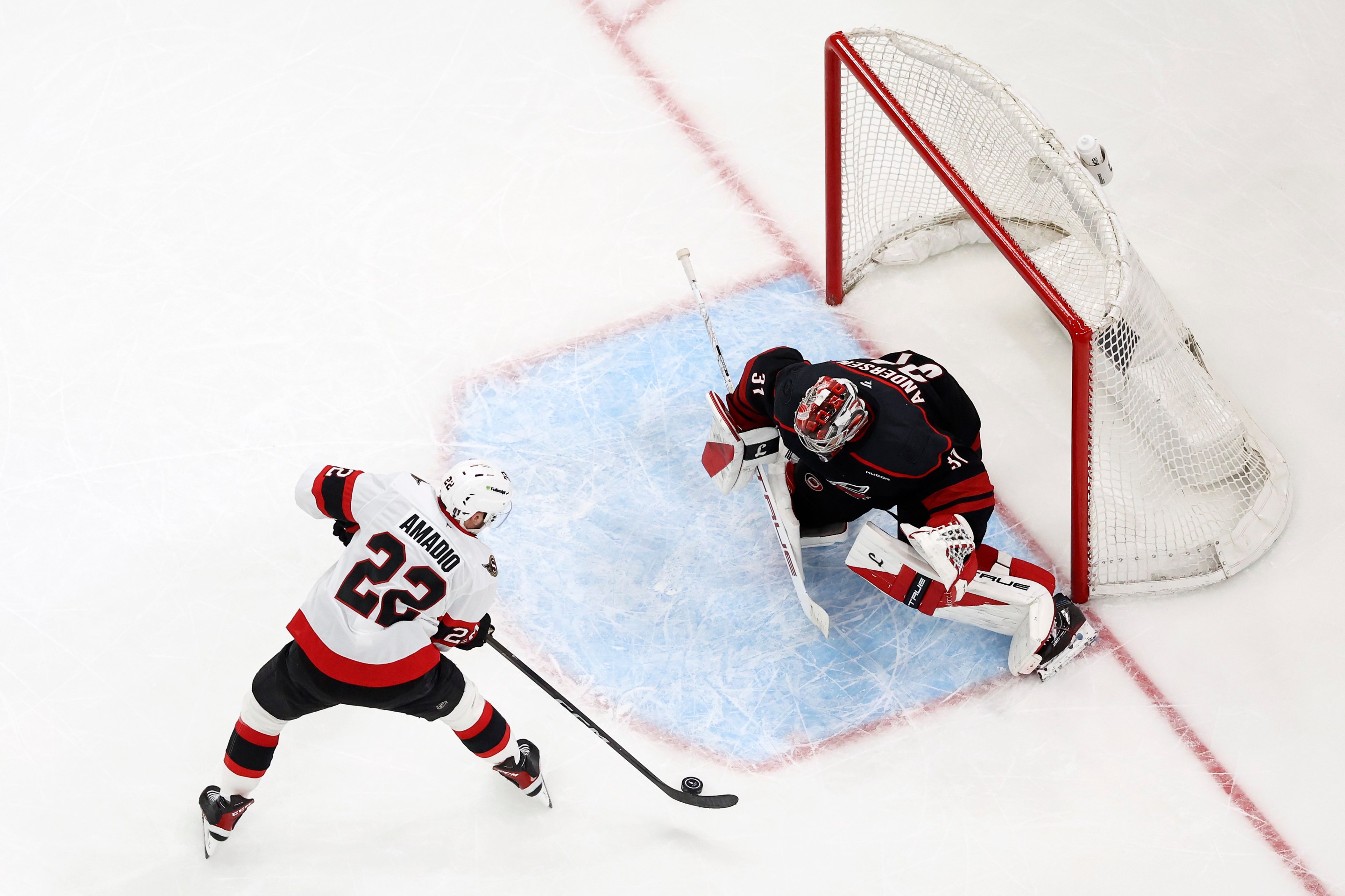 Frederik Andersen #31 of the Carolina Hurricanes makes a save against Michael Amadio