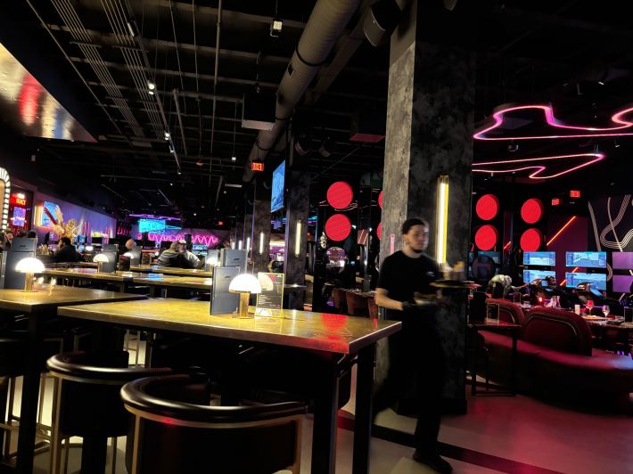 The dim and neon interior of the F1 Arcade.