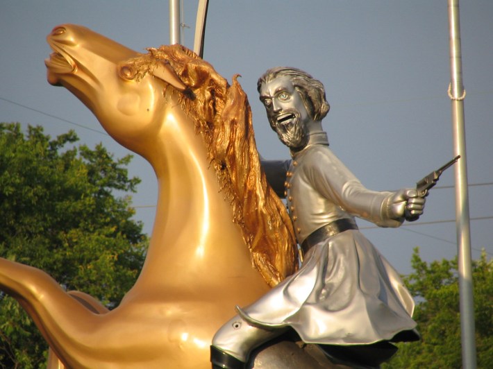 a close-up of the Nathan Bedford Forrest statue taht was once in Nashville. looks like a horrible lizard man on a gold horse