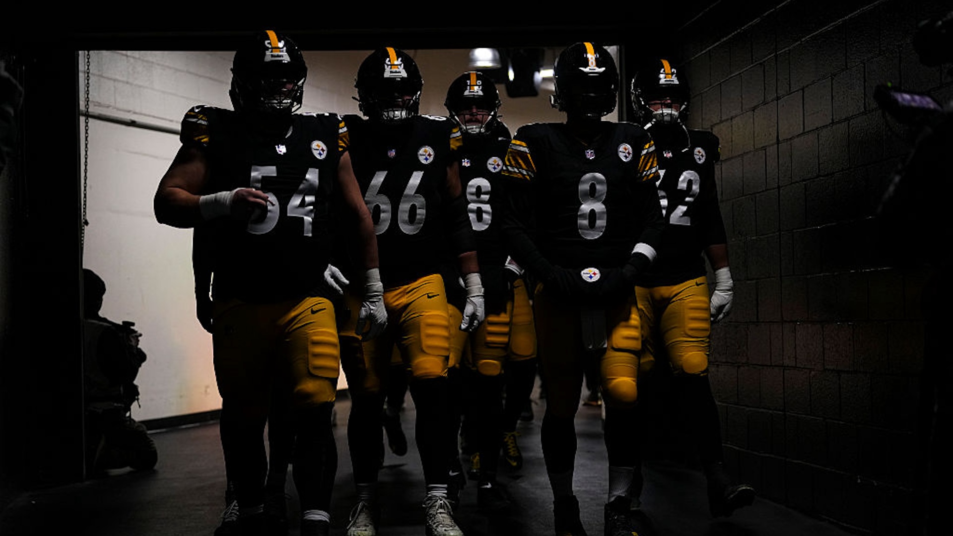 The Pittsburgh Steelers stand in a darkened tunnel
