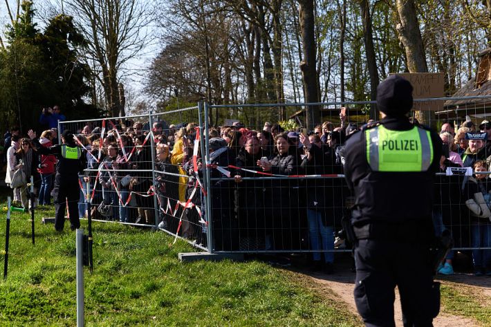 Participants in a demonstration to save the humpback whale stand behind a police cordon.