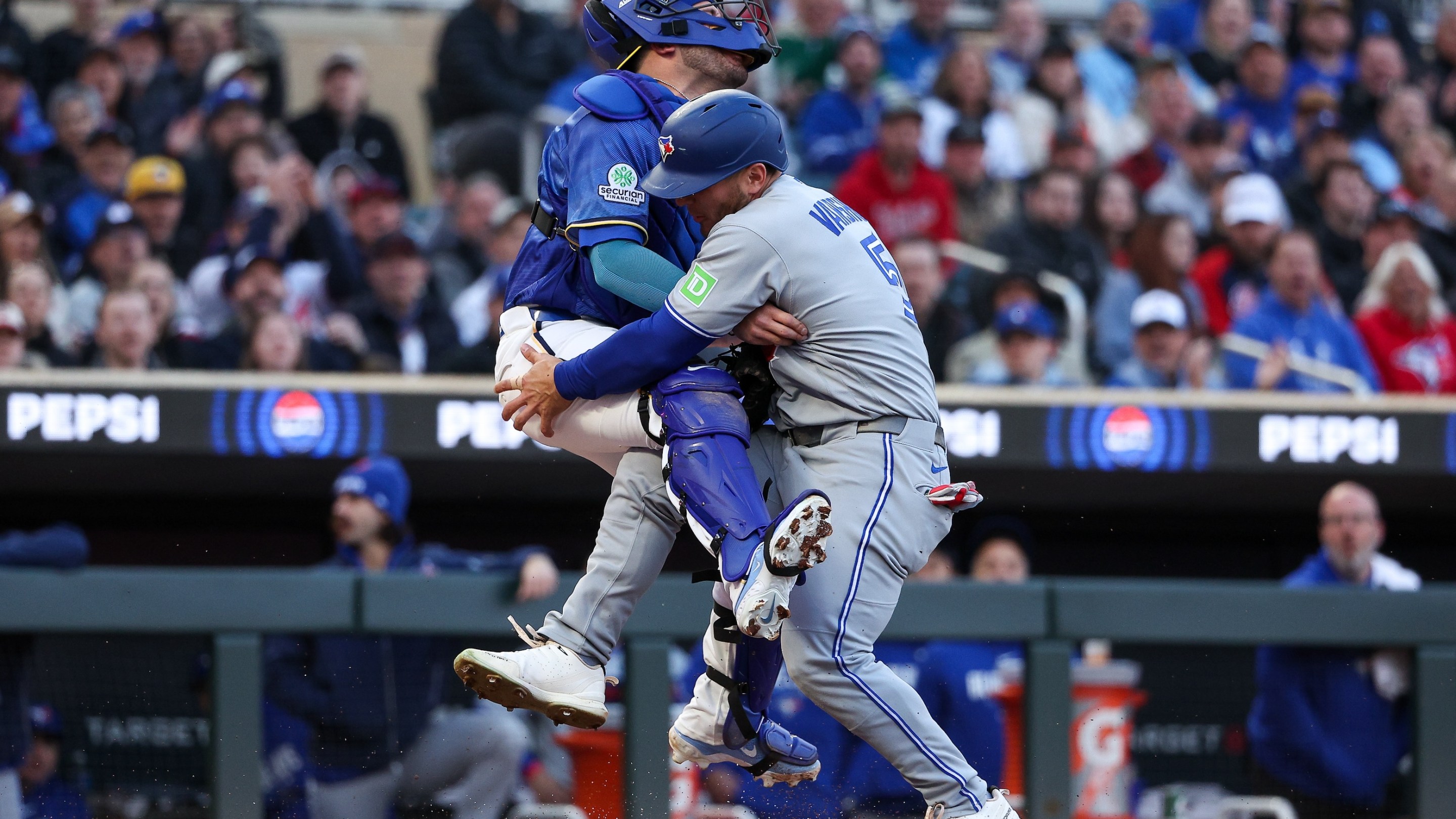 Daulton Varsho #5 of the Toronto Blue Jays collides into Victor Caratini #37 of the Minnesota Twins at home plate during the second inning at Target Field on May 1, 2026.