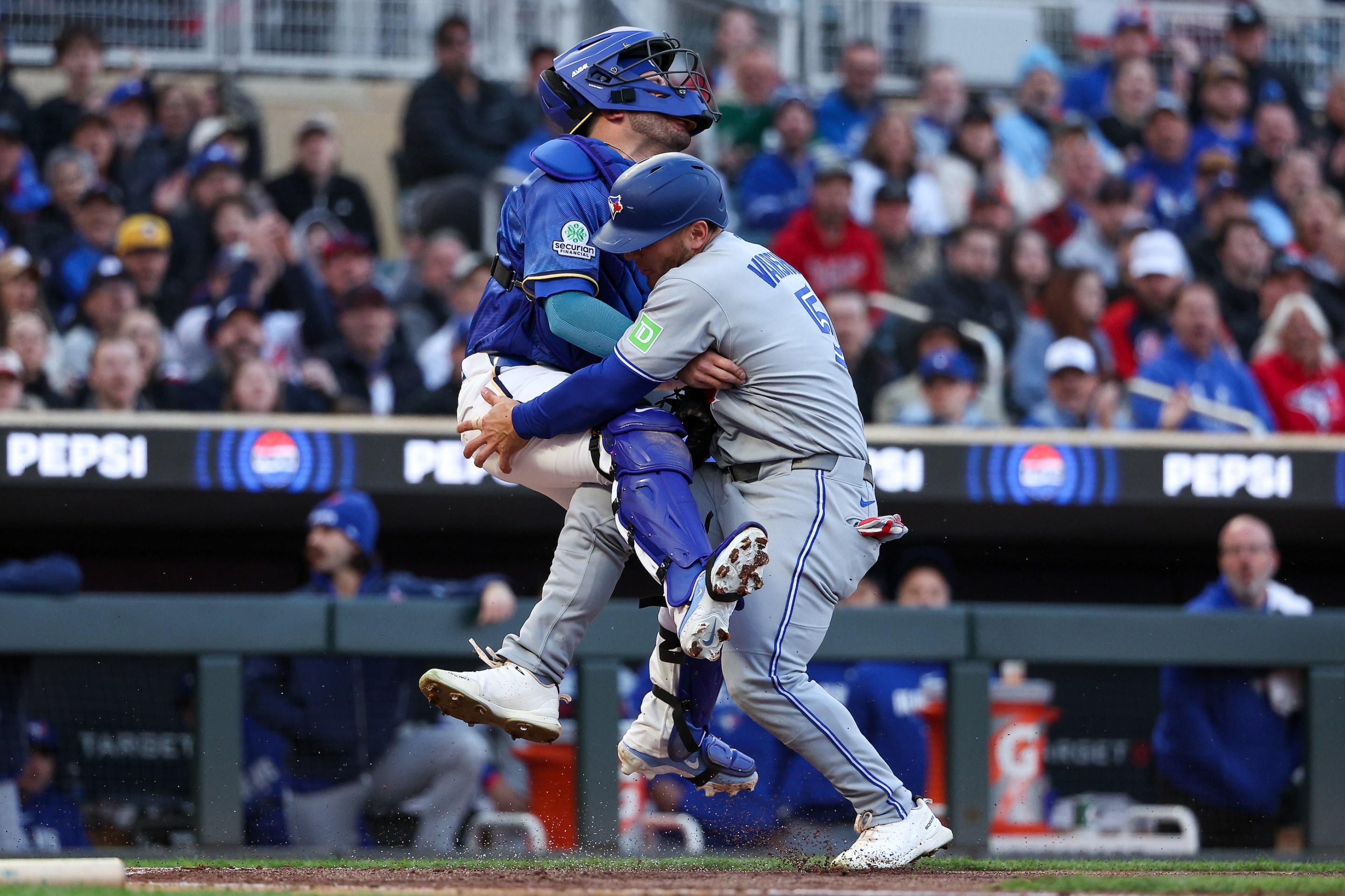 Daulton Varsho #5 of the Toronto Blue Jays collides into Victor Caratini #37 of the Minnesota Twins at home plate during the second inning at Target Field on May 1, 2026.