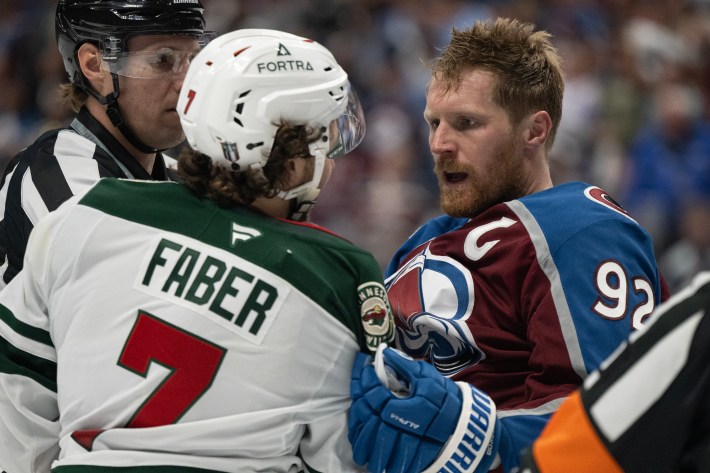Gabriel Landeskog (92) of the Colorado Avalanche and defenseman Brock Faber (7) of the Minnesota Wild talk after fighting