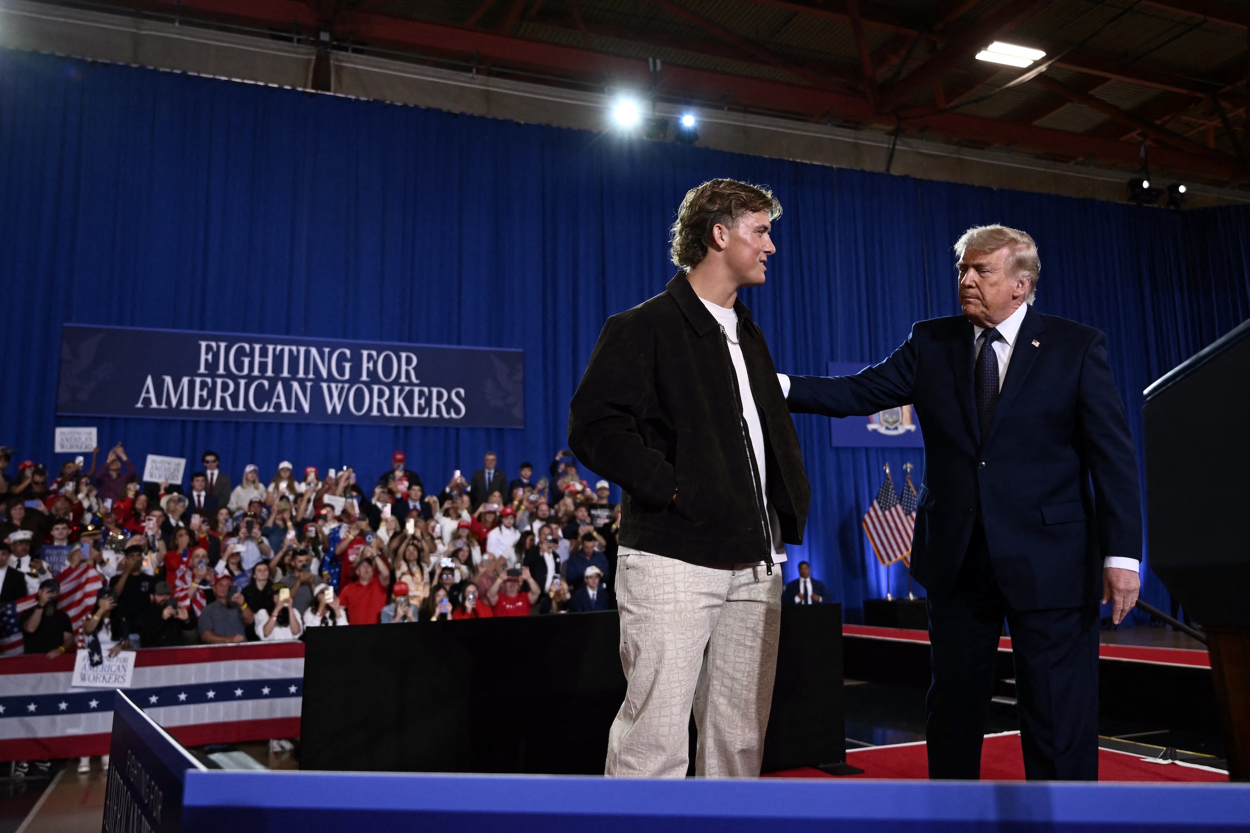 Jaxson Dart and Donald Trump stand on stage at the rally.