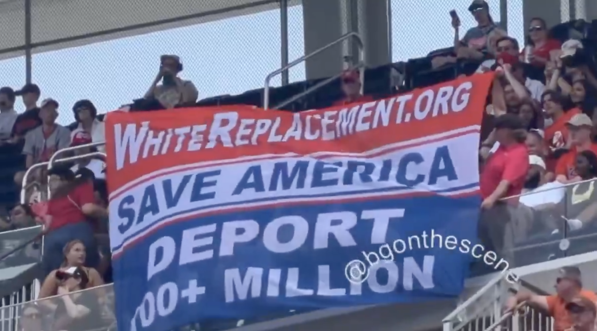 Activists unfurl a large banner reading "SAVE AMERICA DEPORT 100+ MILLION" in the stands at Nationals Park