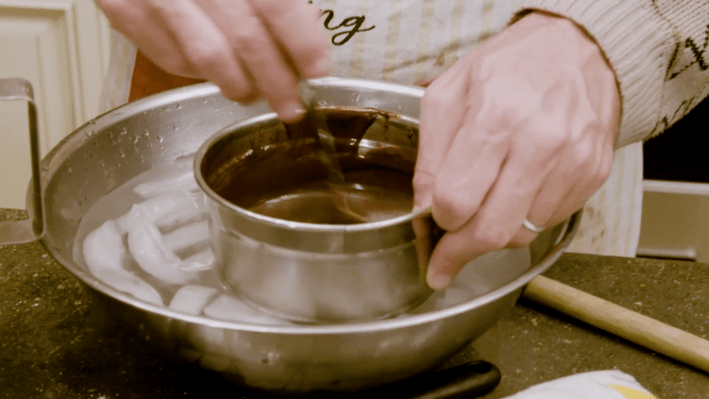 Ganache in a metal bowl, stirring in an ice bath.