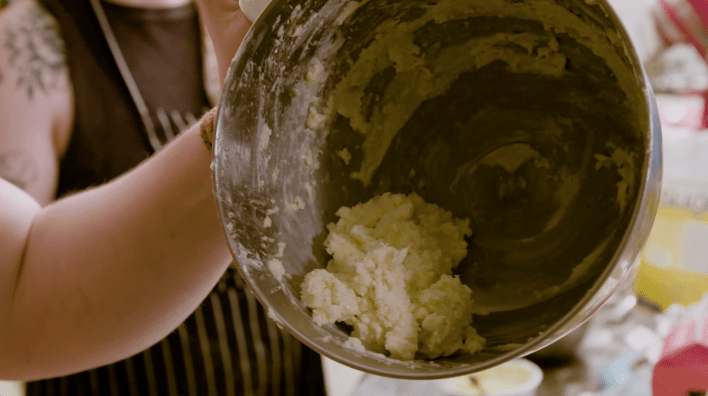 Chunky, curdled buttercream in a bowl.