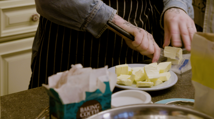 Kelsey slices butter onto a plate, for warming.