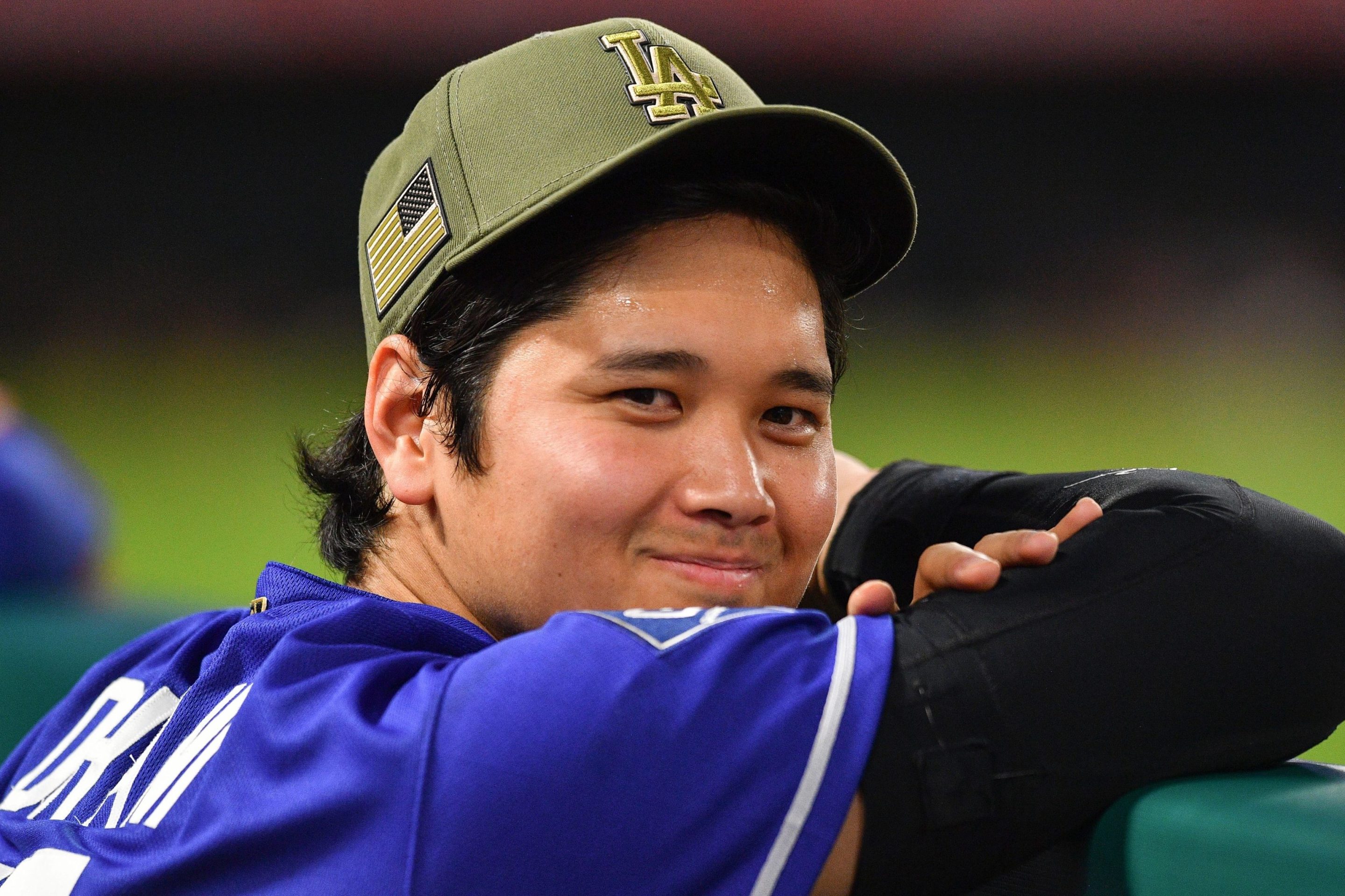 Los Angeles Dodgers designated hitter Shohei Ohtani (17) looks on in the dugout during the MLB game between the Los Angeles Dodgers versus the Los Angeles Angels on May 16, 2026 at Angel Stadium in Anaheim, CA. He has a smile on his face.