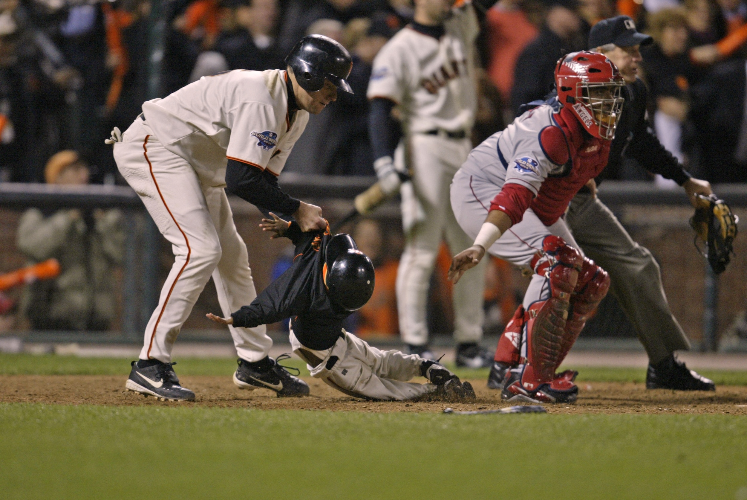 JT Snow pulls three-year-old Darren Baker out of harm's way at homeplate.