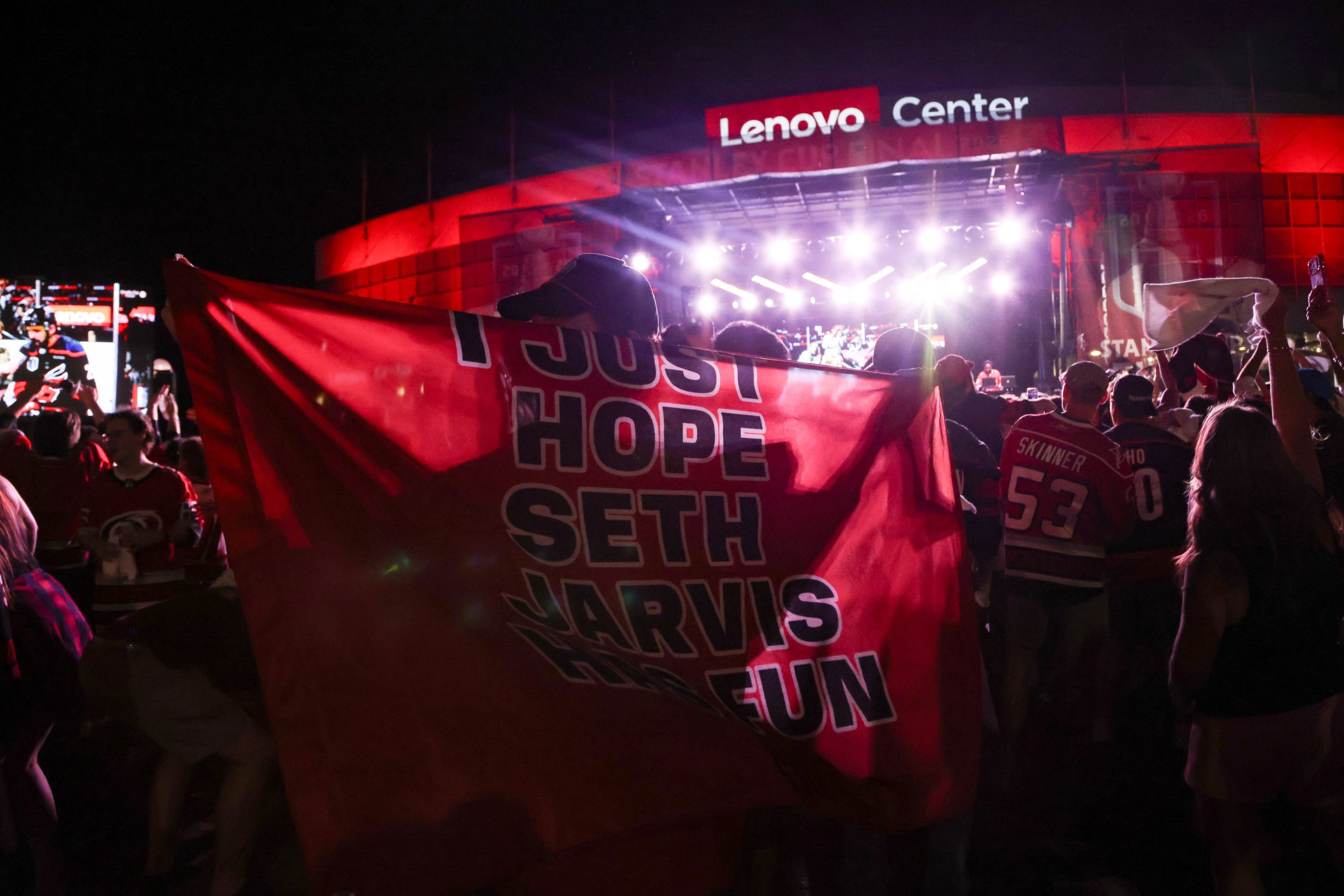 fan holds a cape reading "I just hope Seth Jarvis has fun" after game two of the Stanley Cup Finals on June 4, 2026 at Lenovo Arena