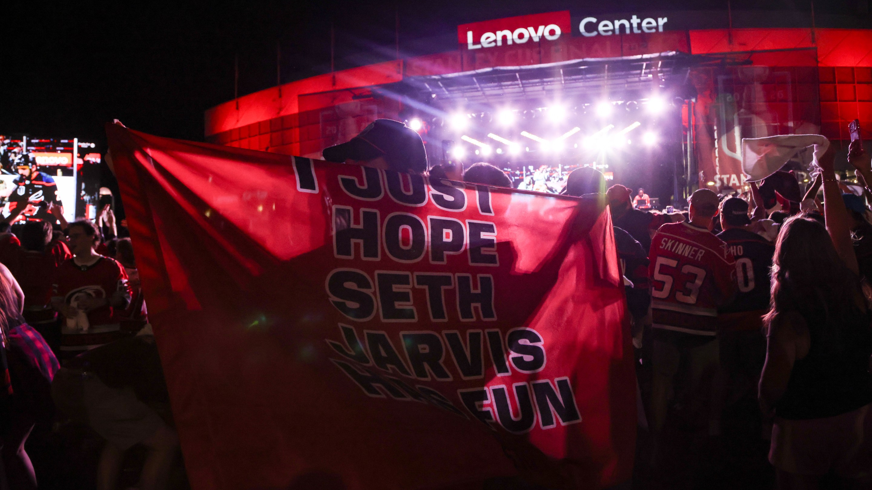 fan holds a cape reading "I just hope Seth Jarvis has fun" after game two of the Stanley Cup Finals on June 4, 2026 at Lenovo Arena